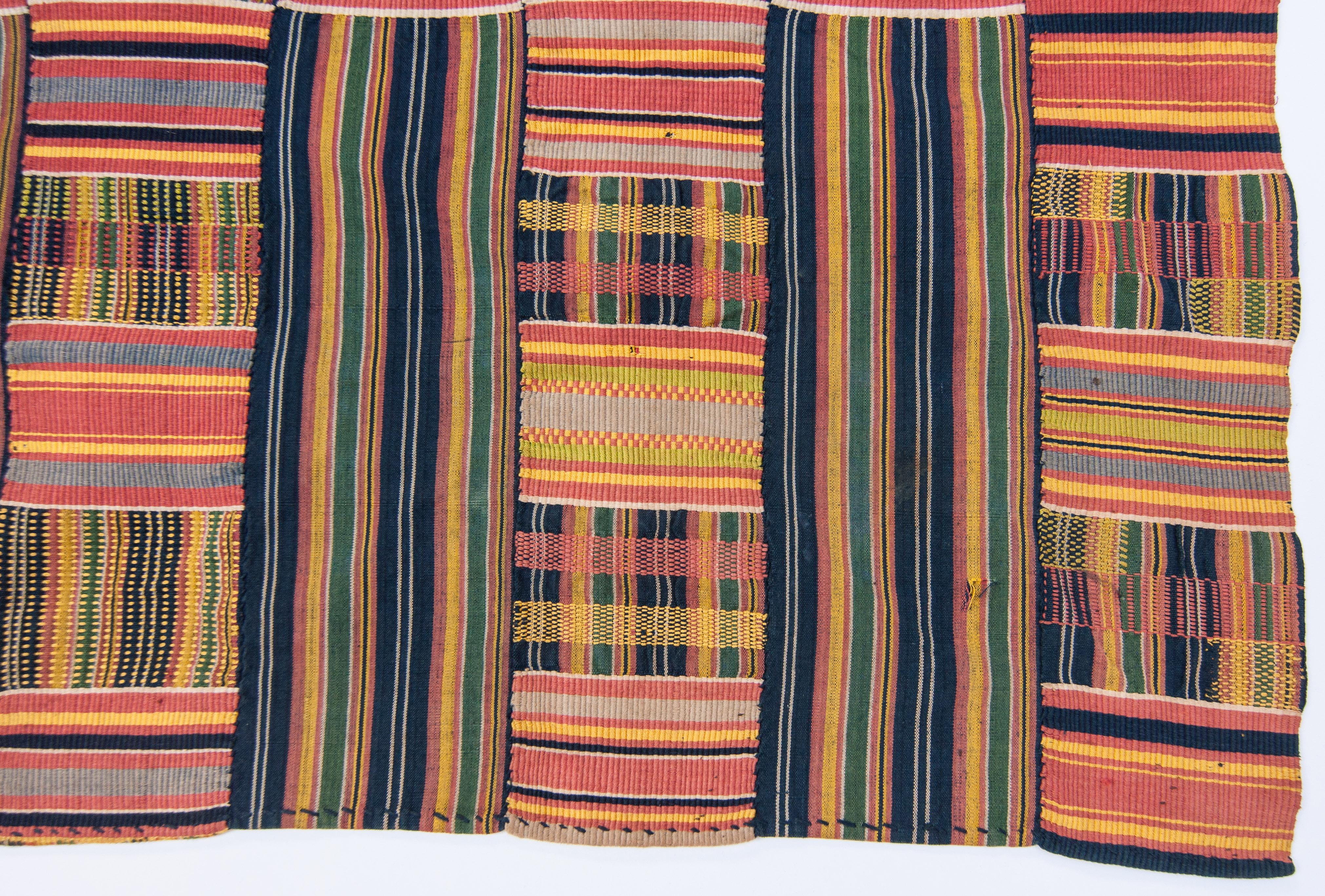 Vintage handwoven Kente Textile. Ewe of Ghana, West Africa. Cotton and silk, mid-20th century. 118 inches long by 69.5 inches wide.
Kente cloths are prestige textiles, with striking colors and geometric patterns, and can be worn by both men and