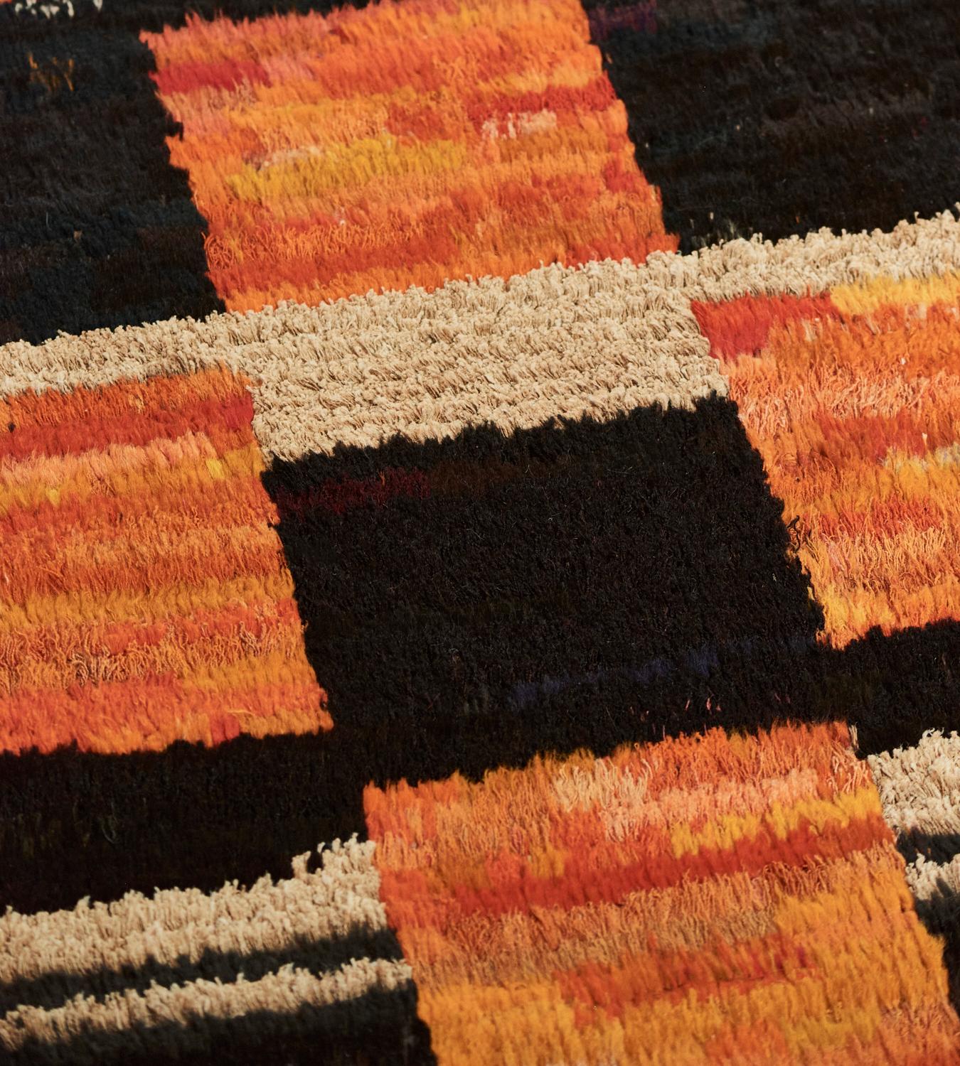 This deep-pile Turkish rug has a central field with a rich chocolate-brown and orange checkerboard design with some bands of ivory, a broad chocolate-brown stripe at each end.