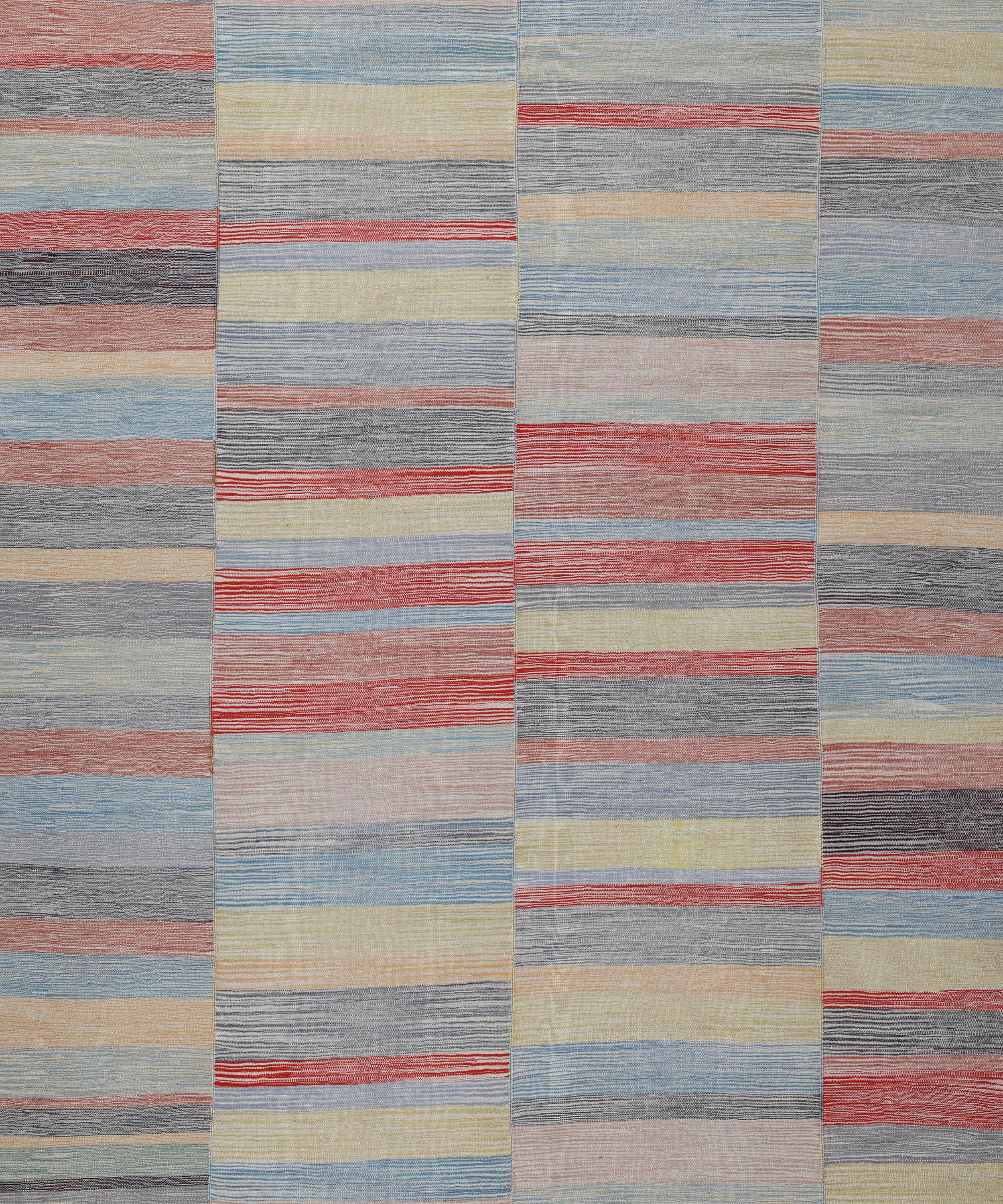 Esta elegante alfombra Mazandaran de tejido plano presenta una delicada disposición de rayas horizontales multicolores en suaves tonos pastel, como azul empolvado, rojo rubor, dorado pálido y carbón apagado. Tejida a mano en estrechos paneles y