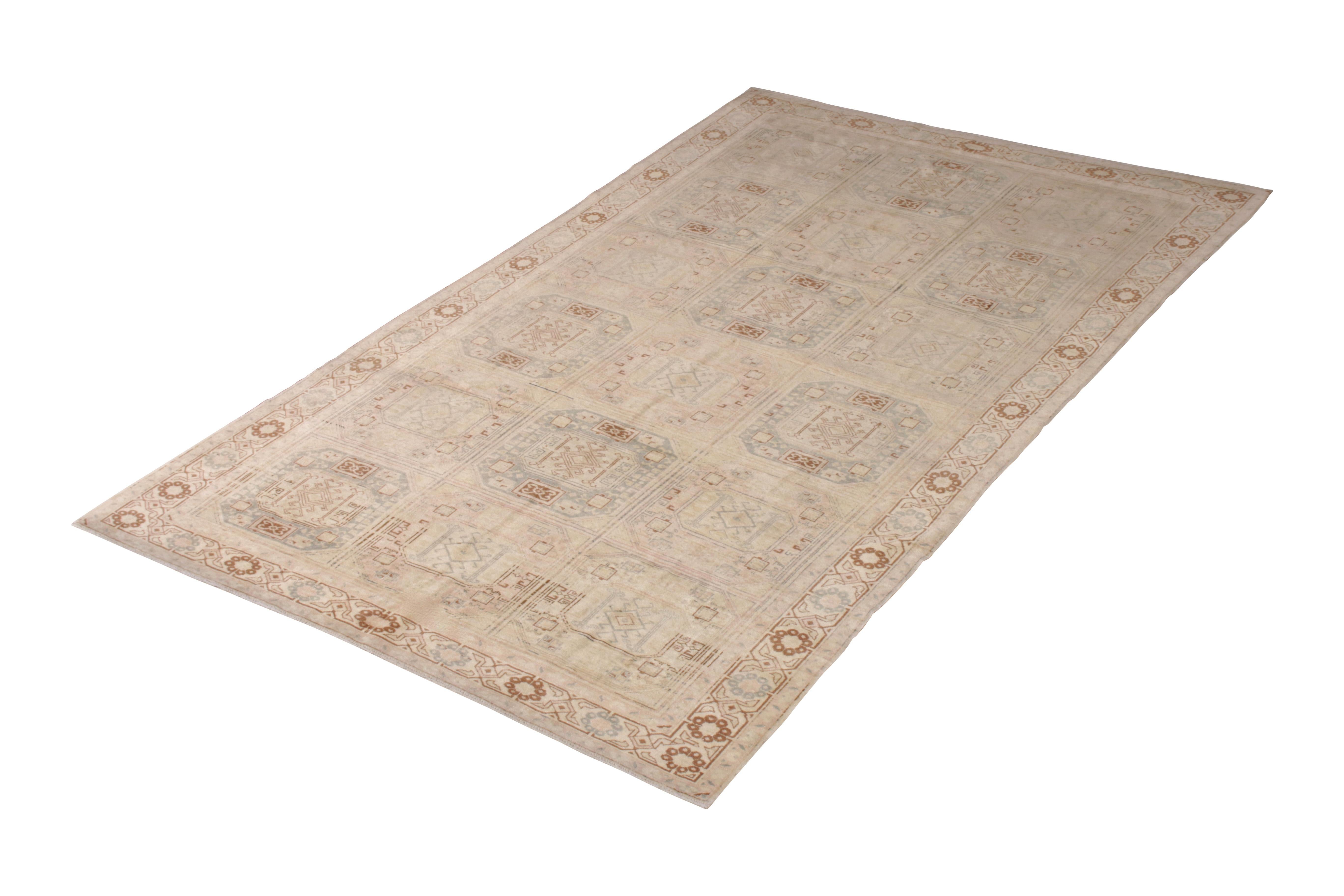 Handwoven in a wool flat-weave originating from Turkey circa 1950-1960, this vintage Kilim rug connotes a unique midcentury Kilim design of the period and region, embracing classic gul motifs in a unique play of subtle pink and blue alternations