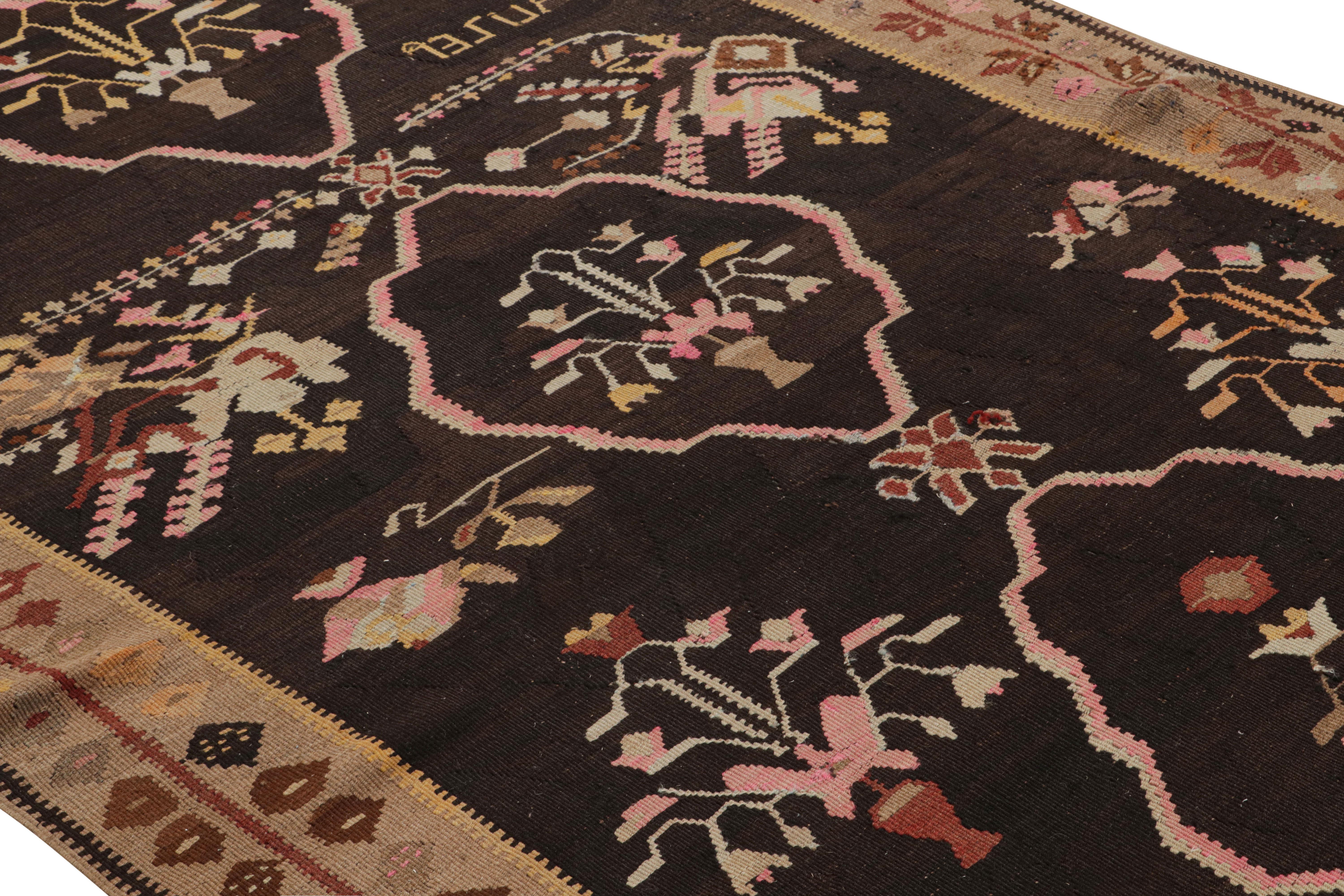 Handwoven in a wool flat-weave originating from Turkey circa 1950-1960, this vintage Kilim rug enjoys a midcentury Bessarabian Kilim style popular to European and Romanian ancestry, seen particularly in the distinctive geometric floral patterns in