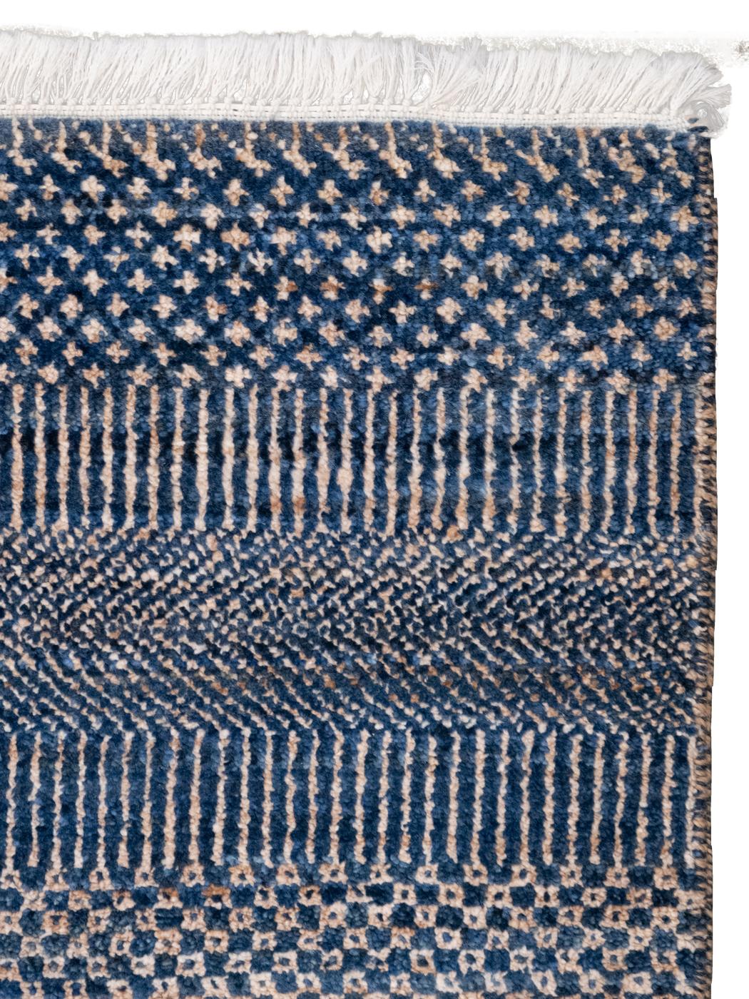 Questo tappeto minimalista in lana, tessuto a mano, dalle dimensioni di 8' x 10', presenta un'armoniosa miscela di sottili tonalità di blu e rame, disposte in strisce orizzontali dalla consistenza morbida. Il design sobrio enfatizza la semplicità e