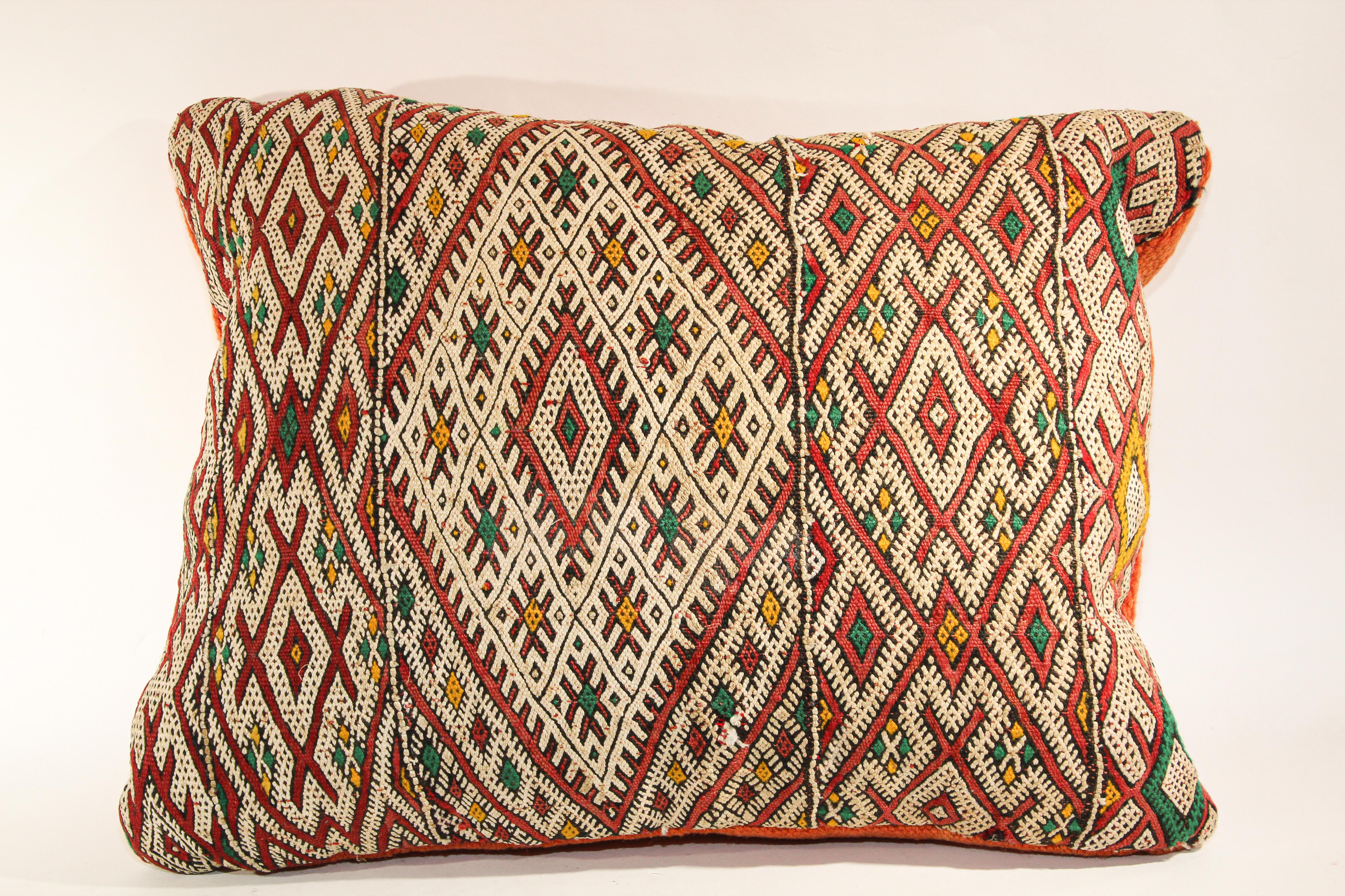 Moroccan ethnic handwoven tribal throw pillow made from a vintage rug.
The front of this Berber pillow and the back are made from a different rug, front is more elaborate and back is more plain.
Geometric North African tribal designs in red, white