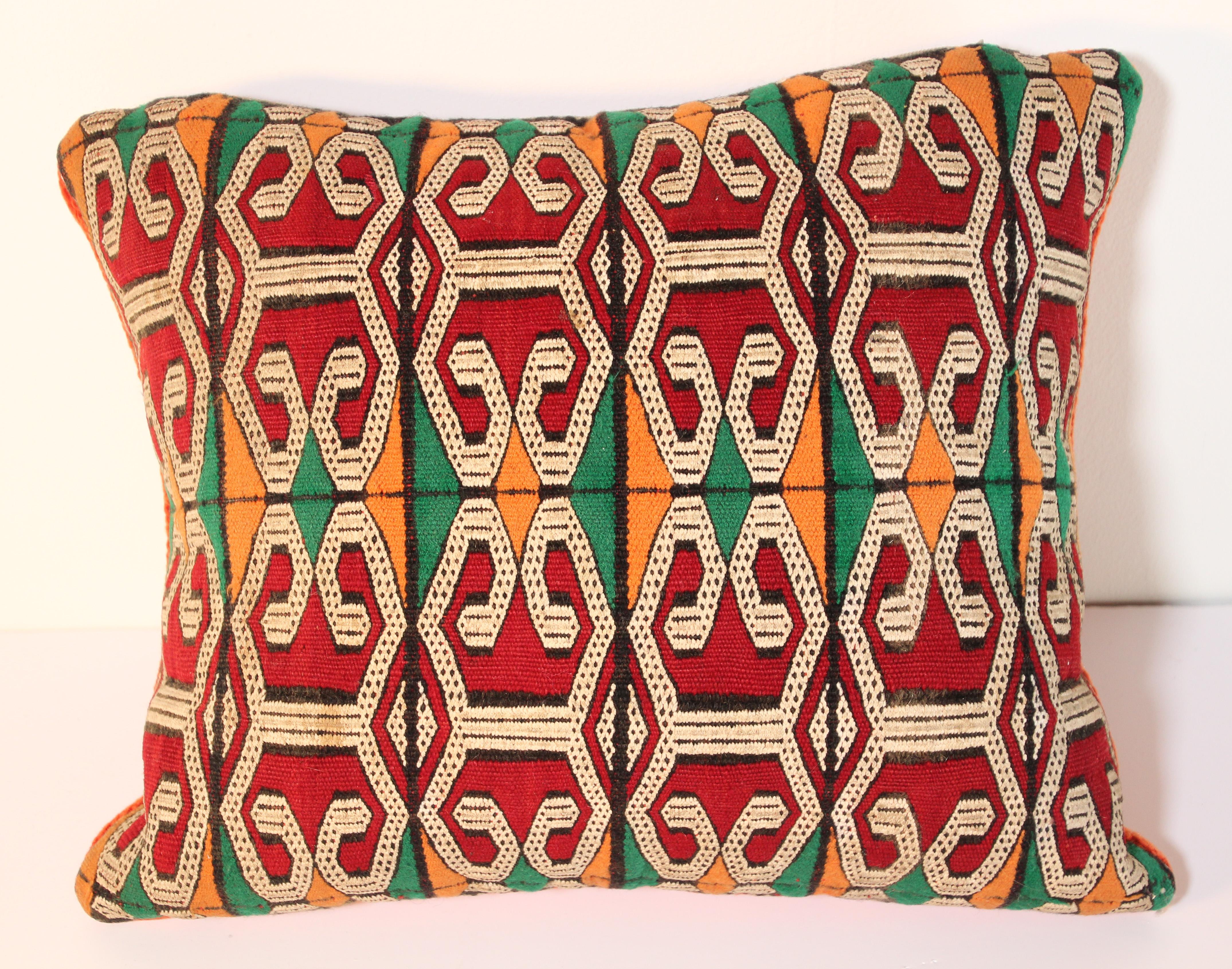 Moroccan Berber handwoven tribal throw pillow made from a vintage rug.
The front and the back are made from a different rug, front is more elaborate and back is more plain.
Geometric African tribal designs in red, white and black and some green