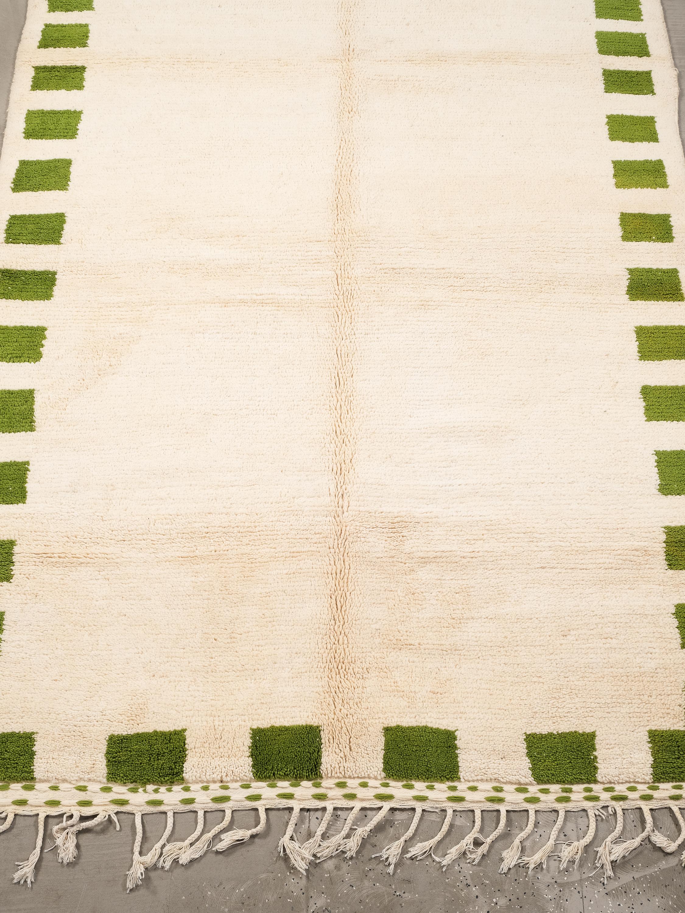 Dieser handgewebte marokkanische Wollteppich (294 x 205 cm) ist ein einzigartiges und visuell beeindruckendes Beispiel für die Handwerkskunst der Berber. Er hat einen cremefarbenen Grundton, der von einer Reihe von grünen, rechteckigen Mustern