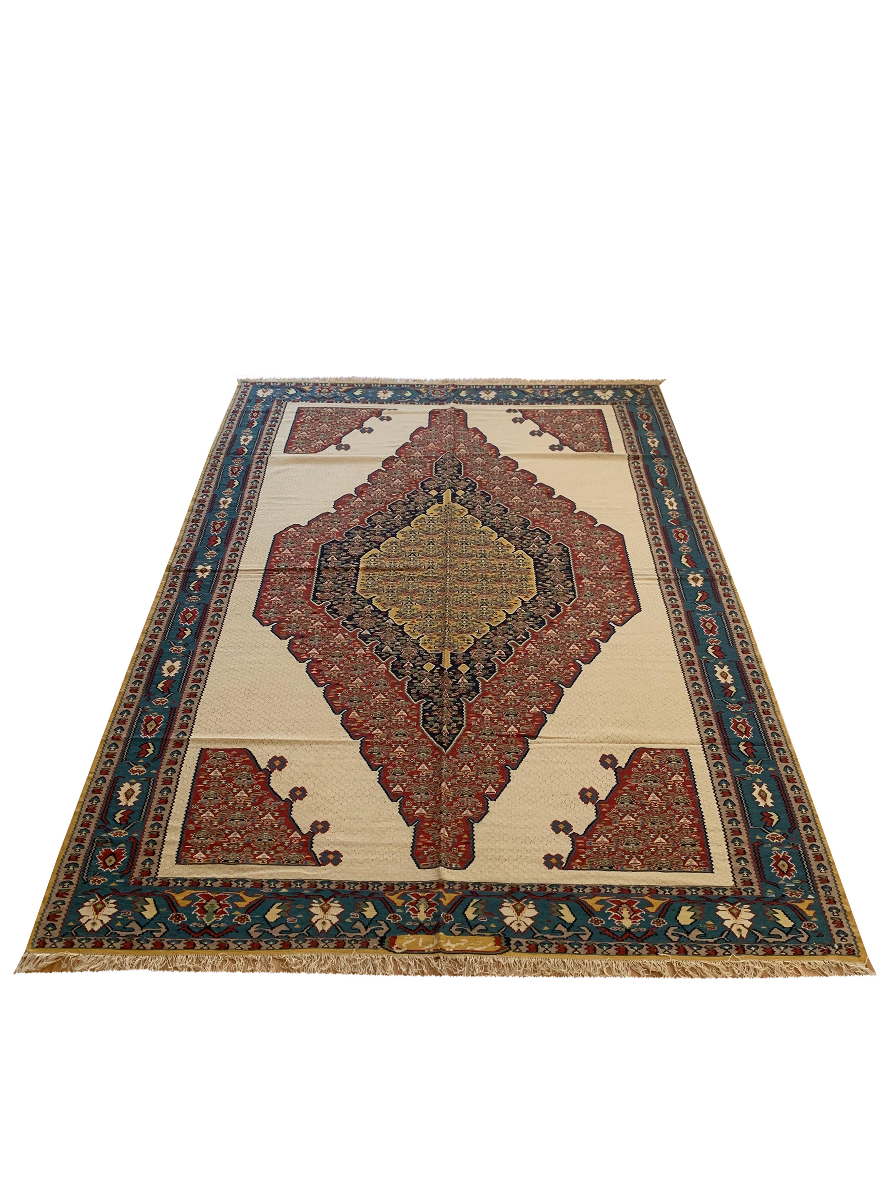 This beautiful silk and wool carpet is a handmade, flatwoven kilim woven in the early 21st century, circa 2010. This Geometric rug is brand new and so is in excellent condition. The design features a cream background with a layered central medallion