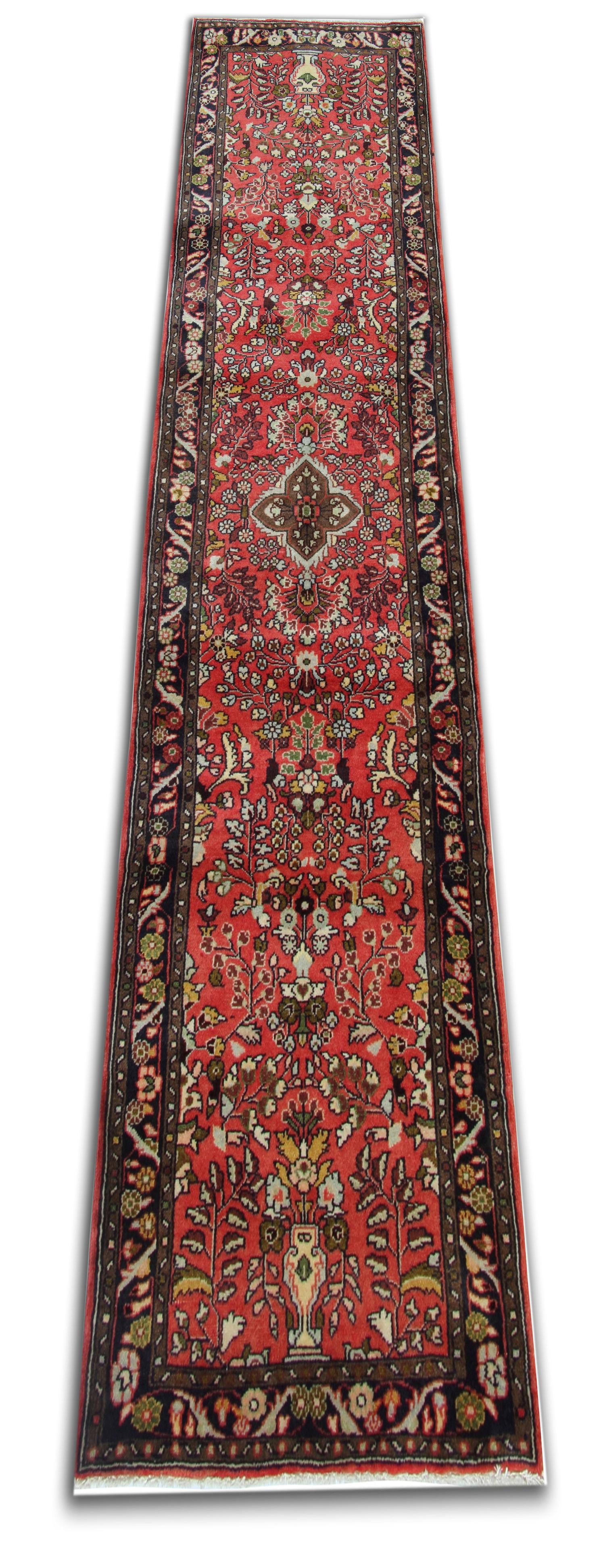 This Vintage carpet was constructed by hand with fine organic materials. Woven with a traditional design and colour palette. Beautifully designed with a rich red background and grey, brown cream and beige accents that make up the sophisticated,
