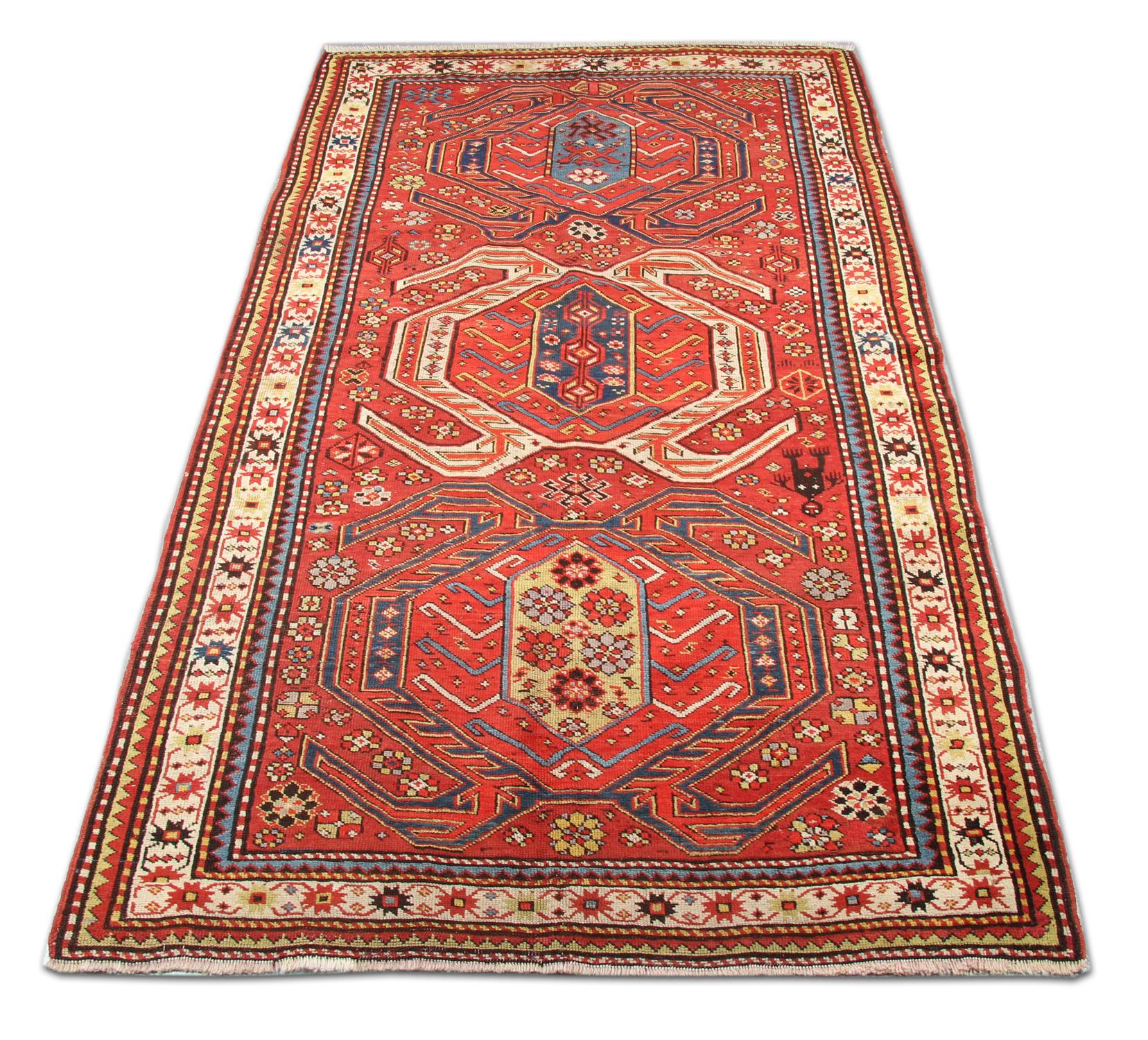 This unique handwoven Lankaran wool rug has been woven with three highly decorative tribal motif medallions on a rich red background with cream, blue and green accents. This piece's colour and design make it the perfect accent rug for any home