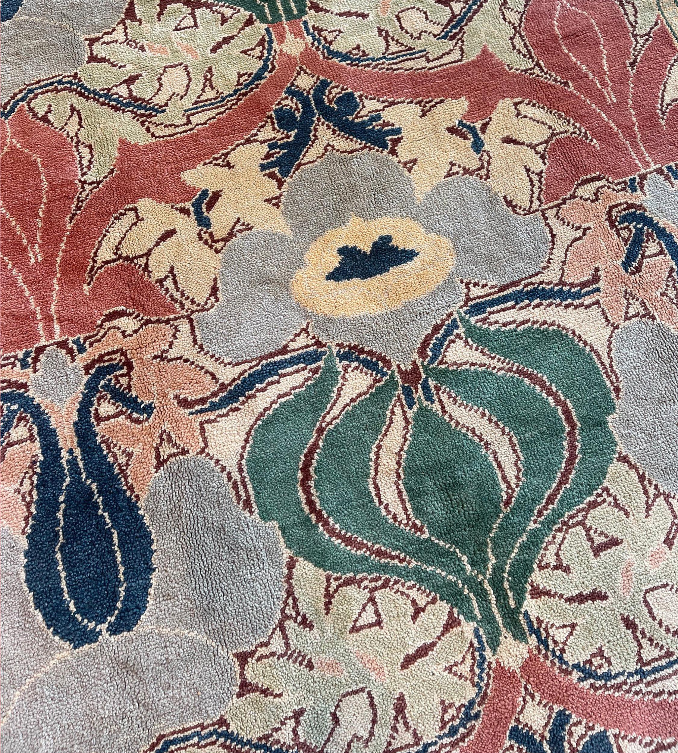 Dieser handgewebte Teppich ist nach einem Arts & Crafts William Morris Design gemustert und zeigt ein Feldmuster mit einer zentralen Terrakotta-Ranke, die kühne stilisierte tiefgrüne Zwiebeln hervorbringt, flankiert von Flora und Ranken in einer