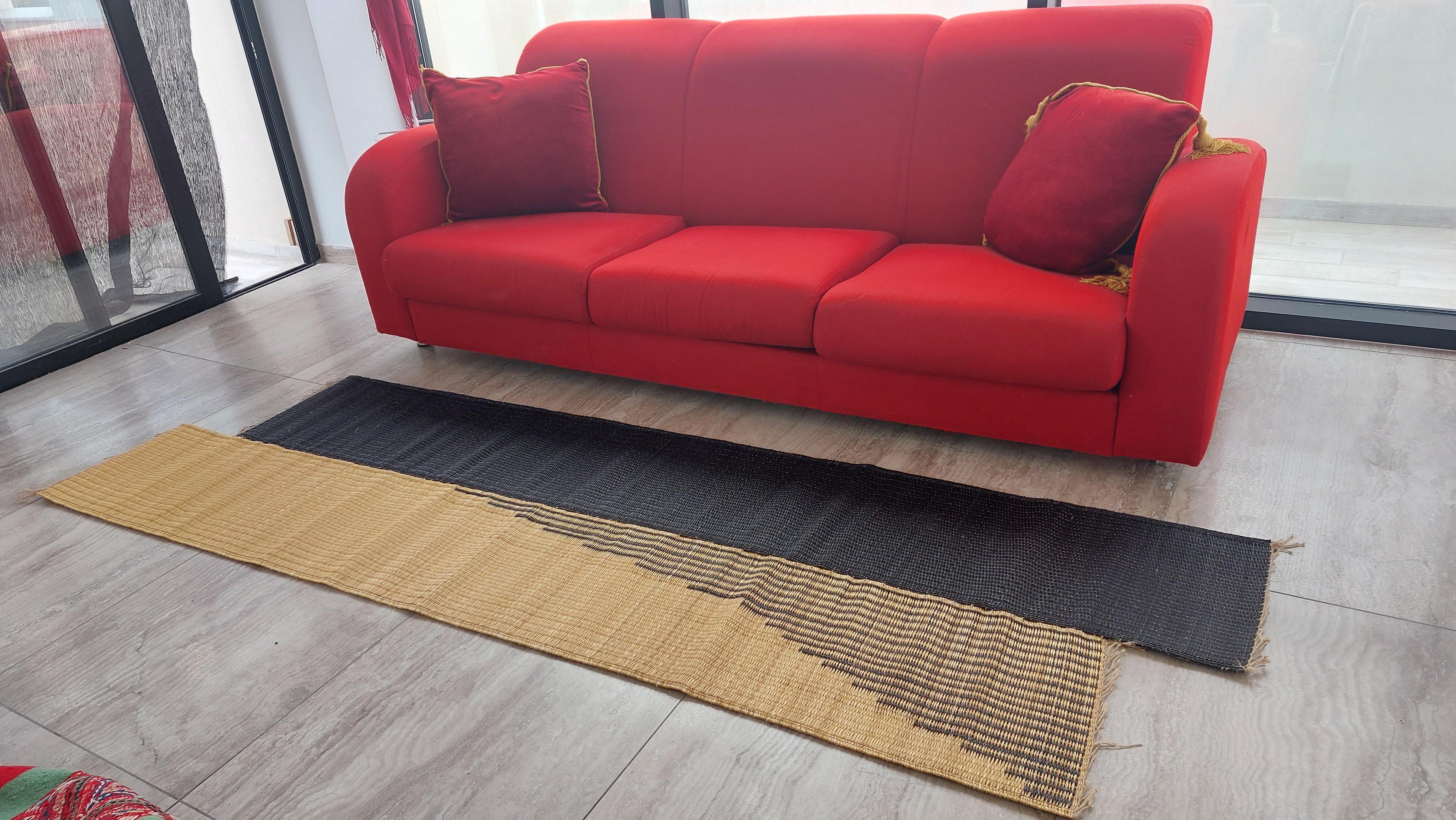 Questo tappeto runner, grazie alla sua forma irregolare, riflette un nuovo modo di assemblare le stuoie in due bande sfalsate e riflette il contributo dell'artigianato del design nell'arte della tessitura delle stuoie in Smar (giunco marino).
Questo