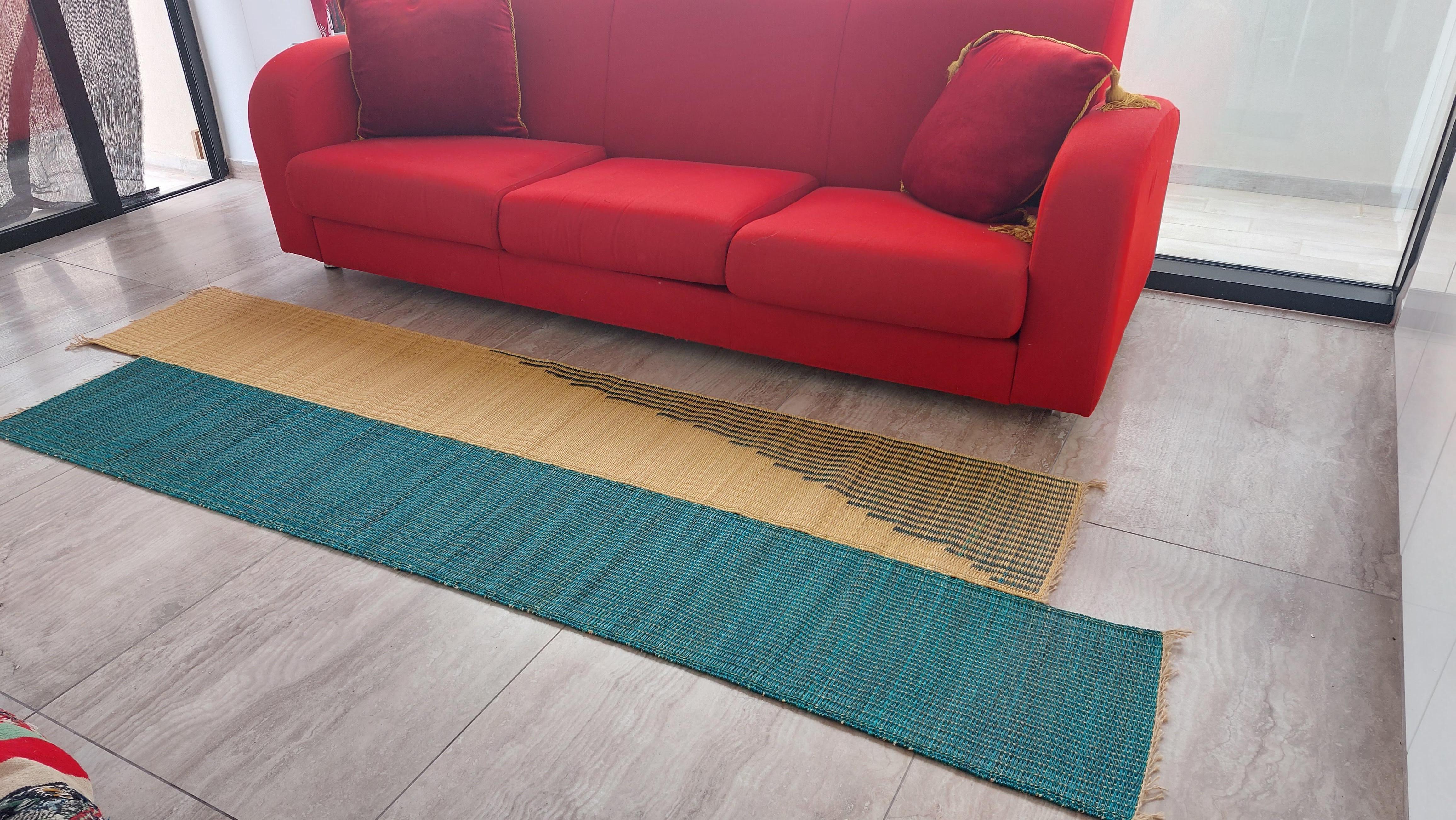 This runner rug, through its irregular shape, reflects a new way of assembling mats in 2 staggered bands, and reflects the contribution of design crafts in the art of weaving mats in Smar (sea rush).
This irregularly shaped natural fiber rug created