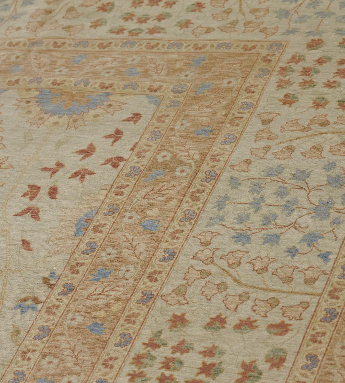 This revival Tabriz has a shaded sandy-yellow field with an overall design of delicate polychrome palmettes surrounded by scrolling floral and leafy vine, in a broad ivory border with light blue and rust-brown delicate small floral sprays and