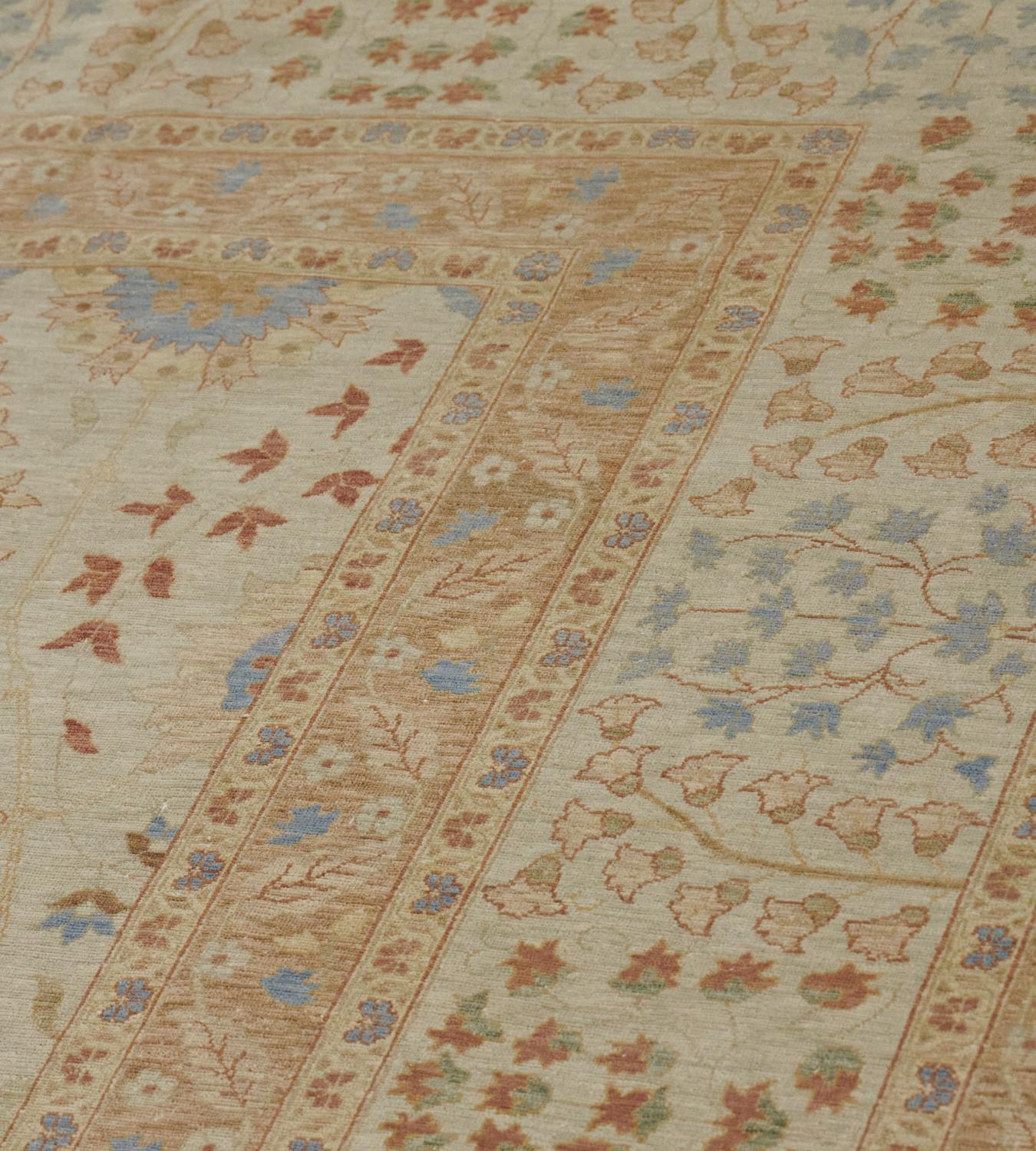 Ce Tabriz de renaissance présente un champ jaune sable nuancé avec un motif général de délicates palmettes polychromes entourées de rinceaux de fleurs et de feuilles de vigne, dans une large bordure ivoire avec de délicates petites gerbes de fleurs