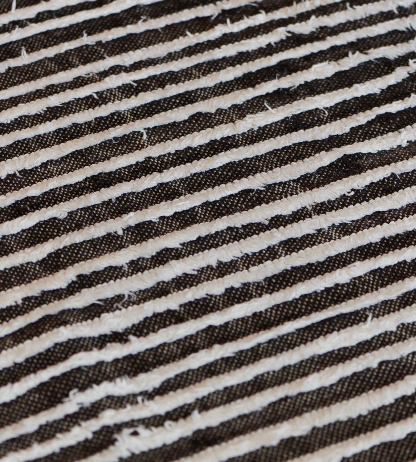 Dieser handgewebte, türkische Deco-Teppich zeichnet sich durch ein hochtiefes, geripptes Feld in Anthrazit und Elfenbein aus.