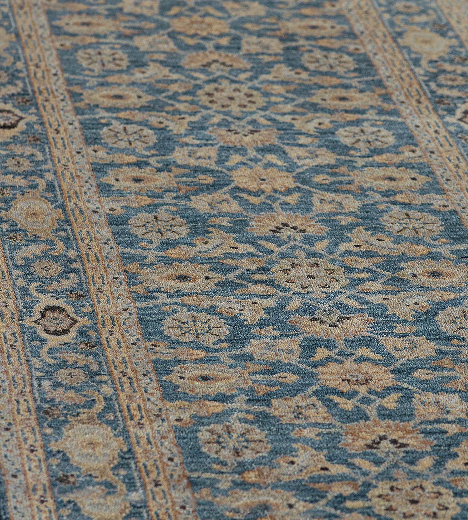The light blue field with an overall design of dense sandy-yellow and mole-brown herati-pattern, in a light blue border of ivory and mole-brown and turtle-palmette vine border between narrow ivory floral vine stripes.
