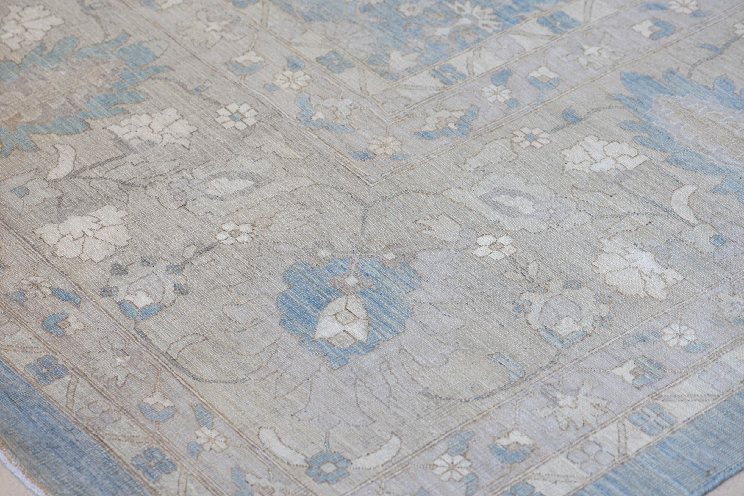 This Tabriz inspired rug features a blue-grey field with an overall design of bold buff-brown linked arches forming bands of cartouches enclosing a dense floral and leafy vine, in a broad buff-brown border of delicate floral vine linking large