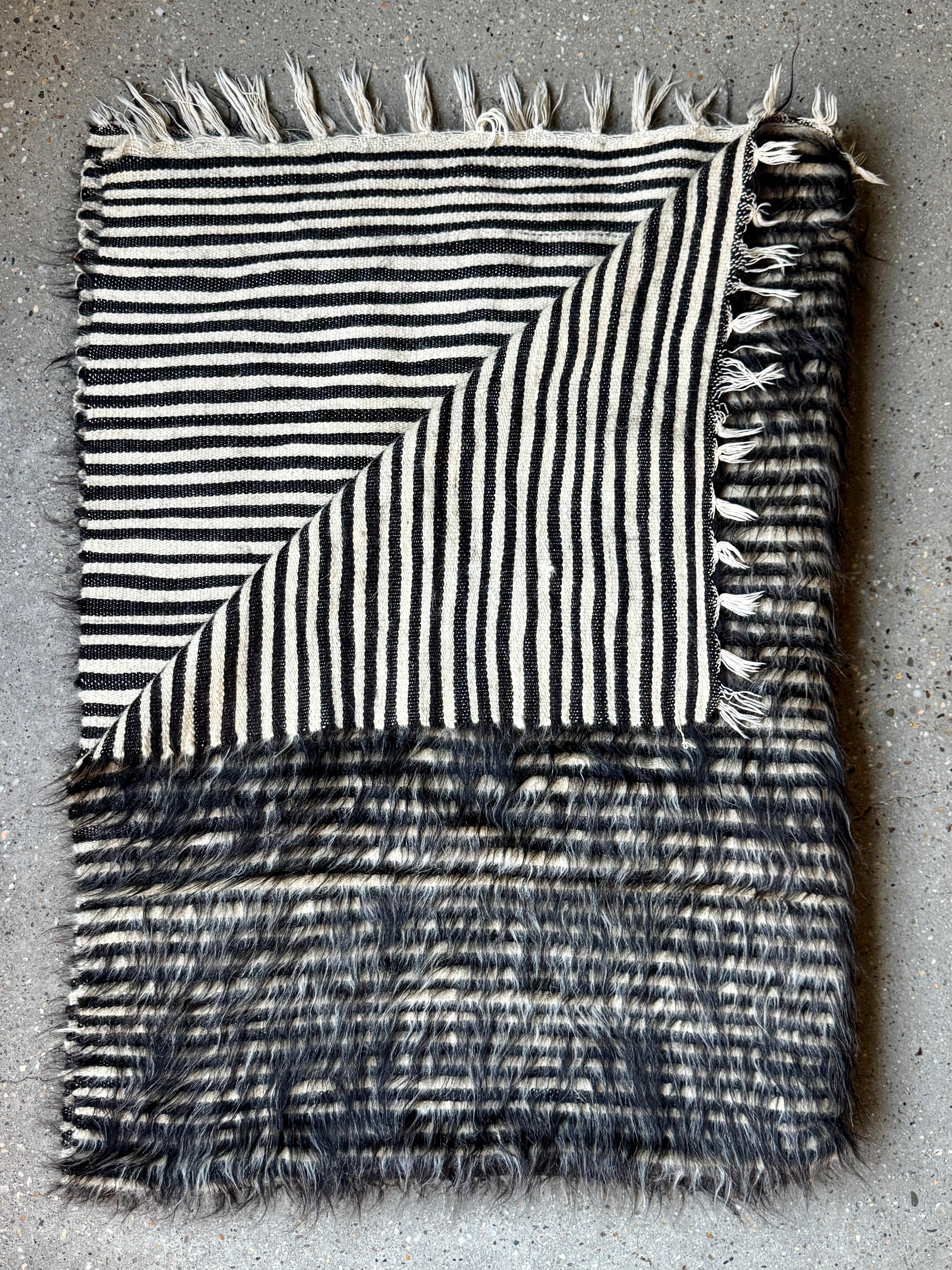 Plaid en poil de chèvre uruguayen tissé à la main avec motif graphique à rayures

Un magnifique jeté tissé à la main en Uruguay, fabriqué à partir de poils de chèvre naturels. Ce textile saisissant présente un design à deux faces : une face avec une