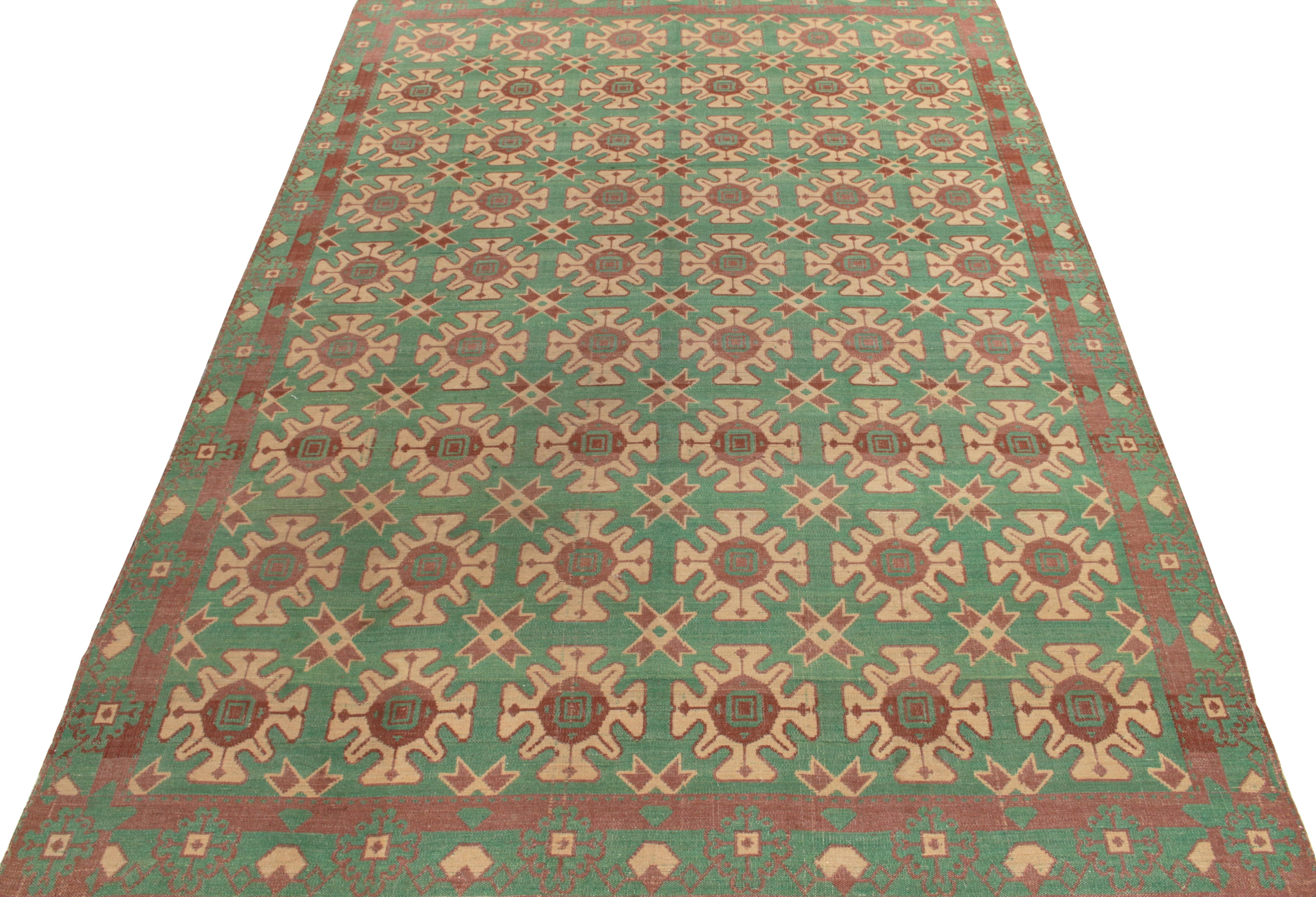 Originating from Turkey circa 1950-1960, a finely handwoven wool vintage kilim rug featuring tribal motifs culminating into a meticulous geometric pattern in beige-brown tones on an aqua green backdrop for a scintillating sense of movement. Bearing