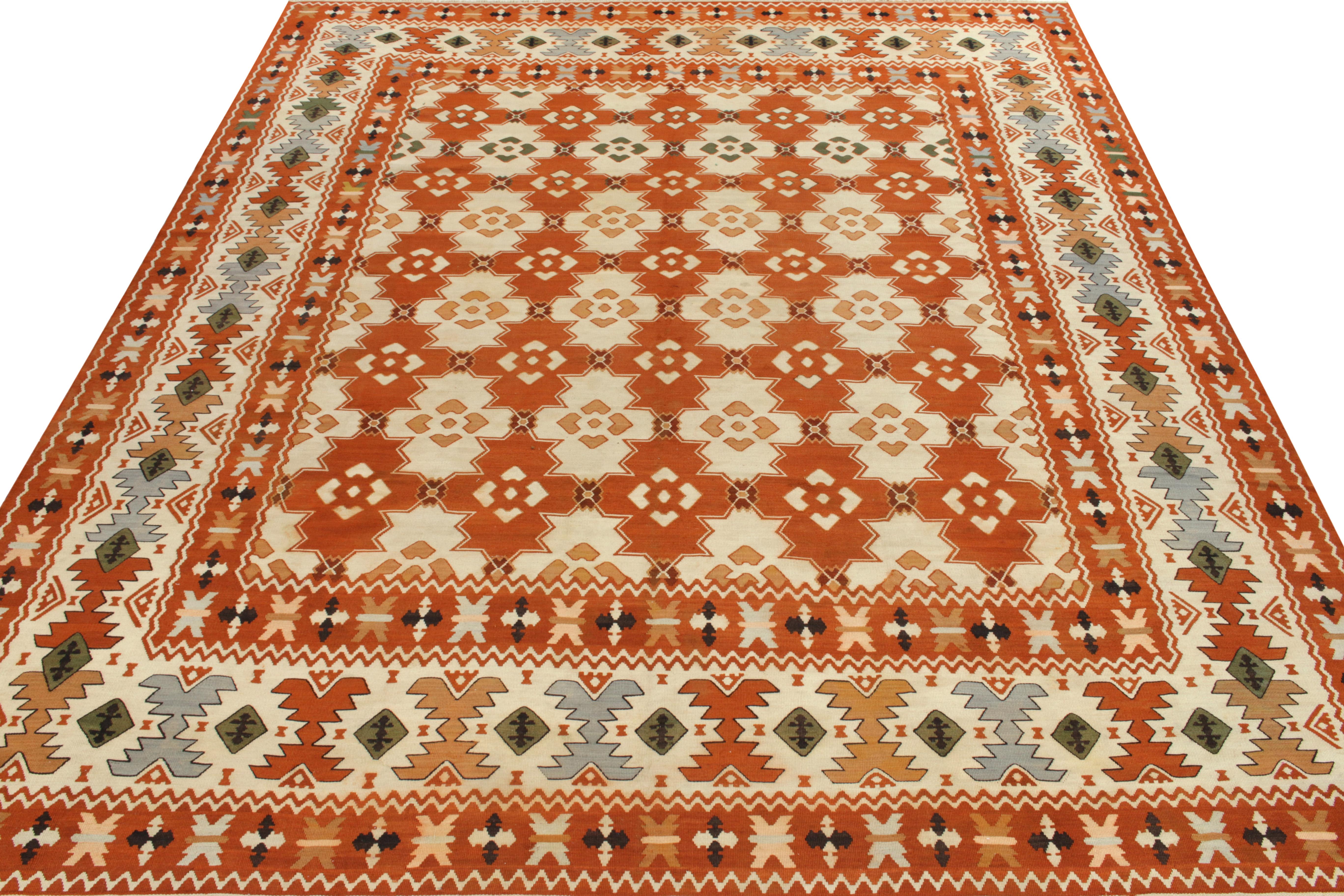 Handwoven in wool originating from Turkey circa 1950-1960, a vibrant vintage Balkan flatweave rug enjoying nomadic sensibilities entering our Kilim & Flatweave collection. The field features a tribal geometric pattern in bright tangerine & stark