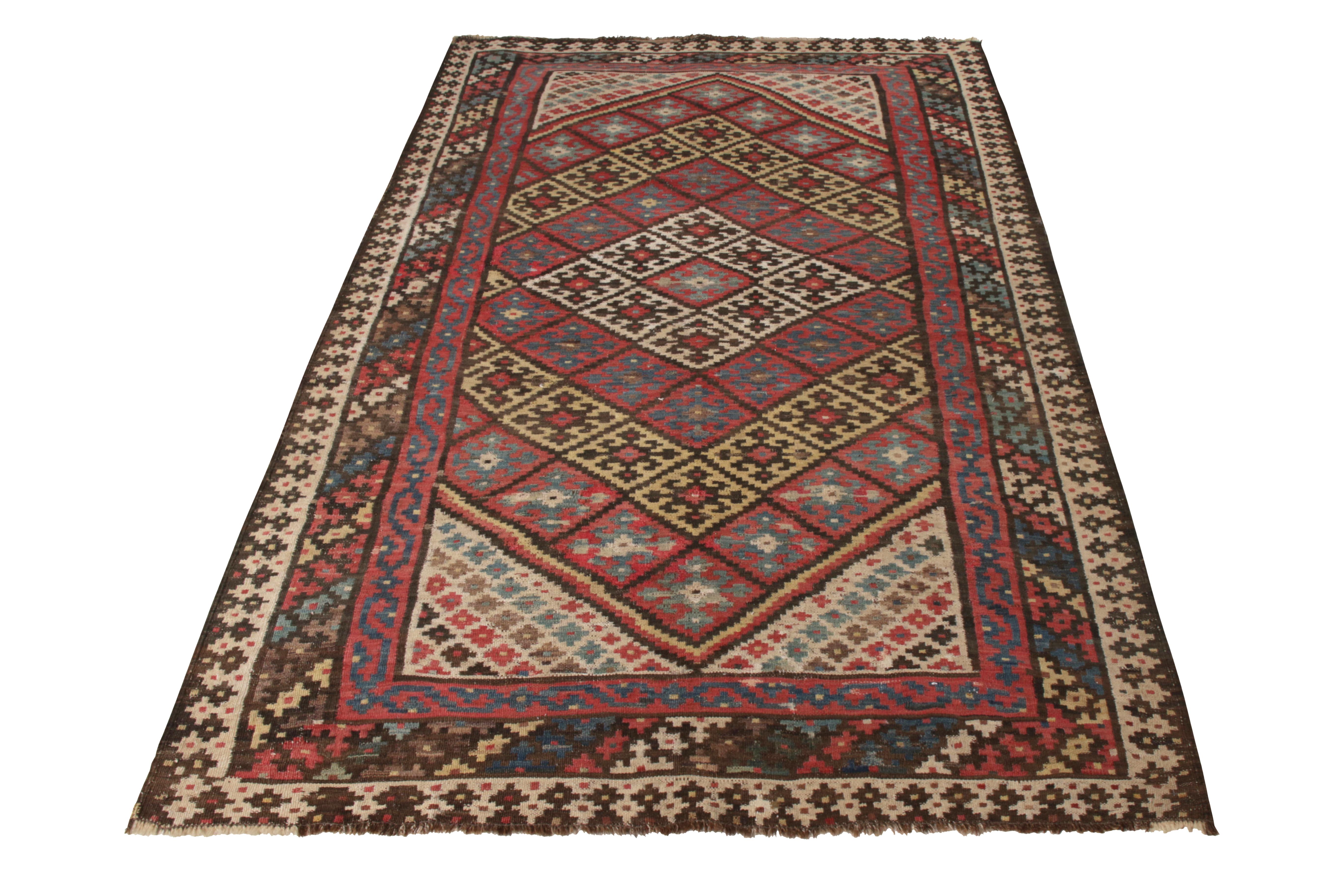 A vintage 5 x 9 Persian Kilim rug of Qashqai design lineage, handwoven in wool originating circa 1950-1960. Enjoying red and beige-brown hues with multicolor accents lending the geometric pattern a playful movement. Inviting yet meticulous among