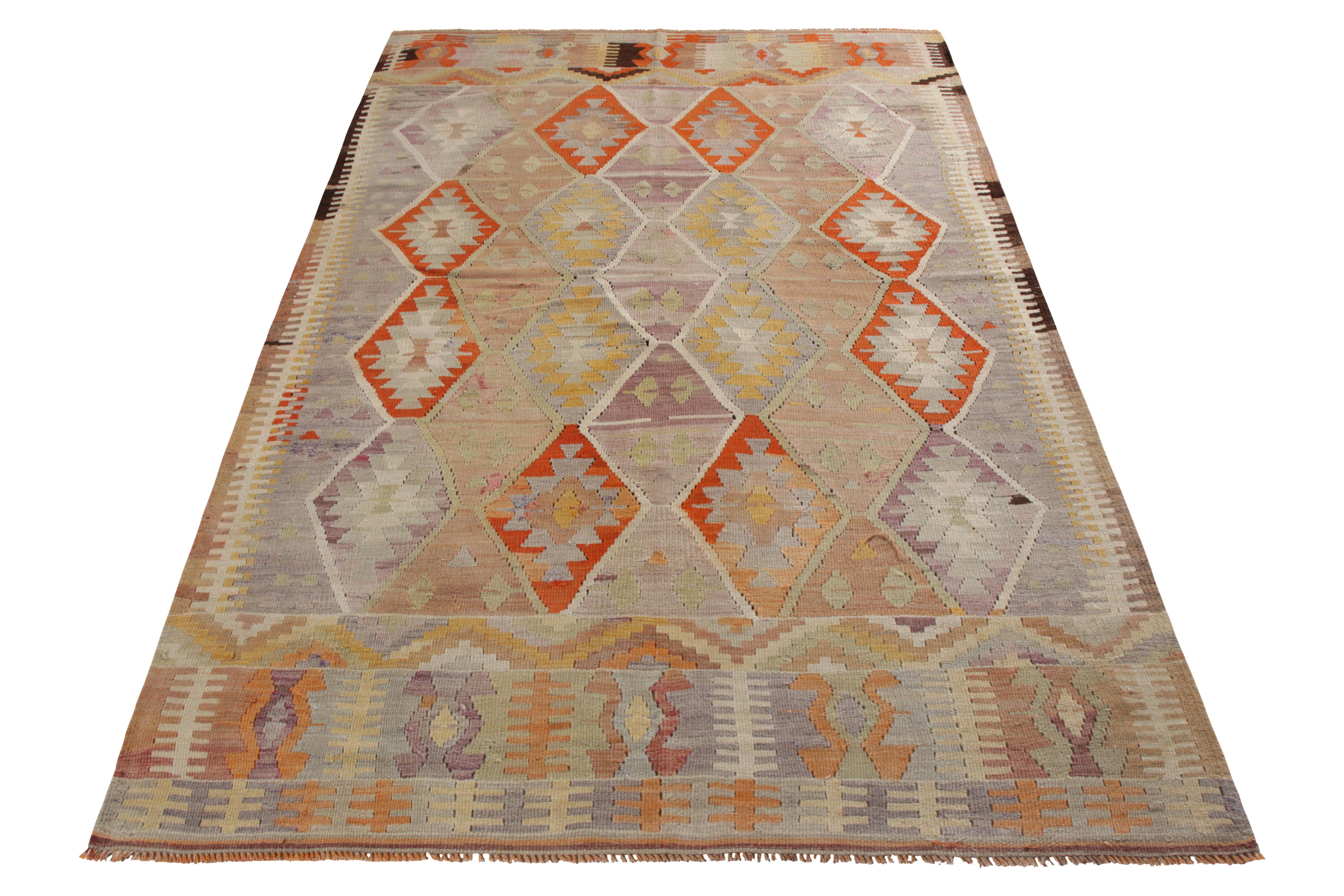 A vintage 6 x 9 Kilim rug, handwoven in wool originating from Turkey circa 1950-1960. Enjoying a slit tapestry weave in tribal geometric patterns, enjoying vibrant orange against pink and blue in the uniquely diverse colorway. Further sporting good