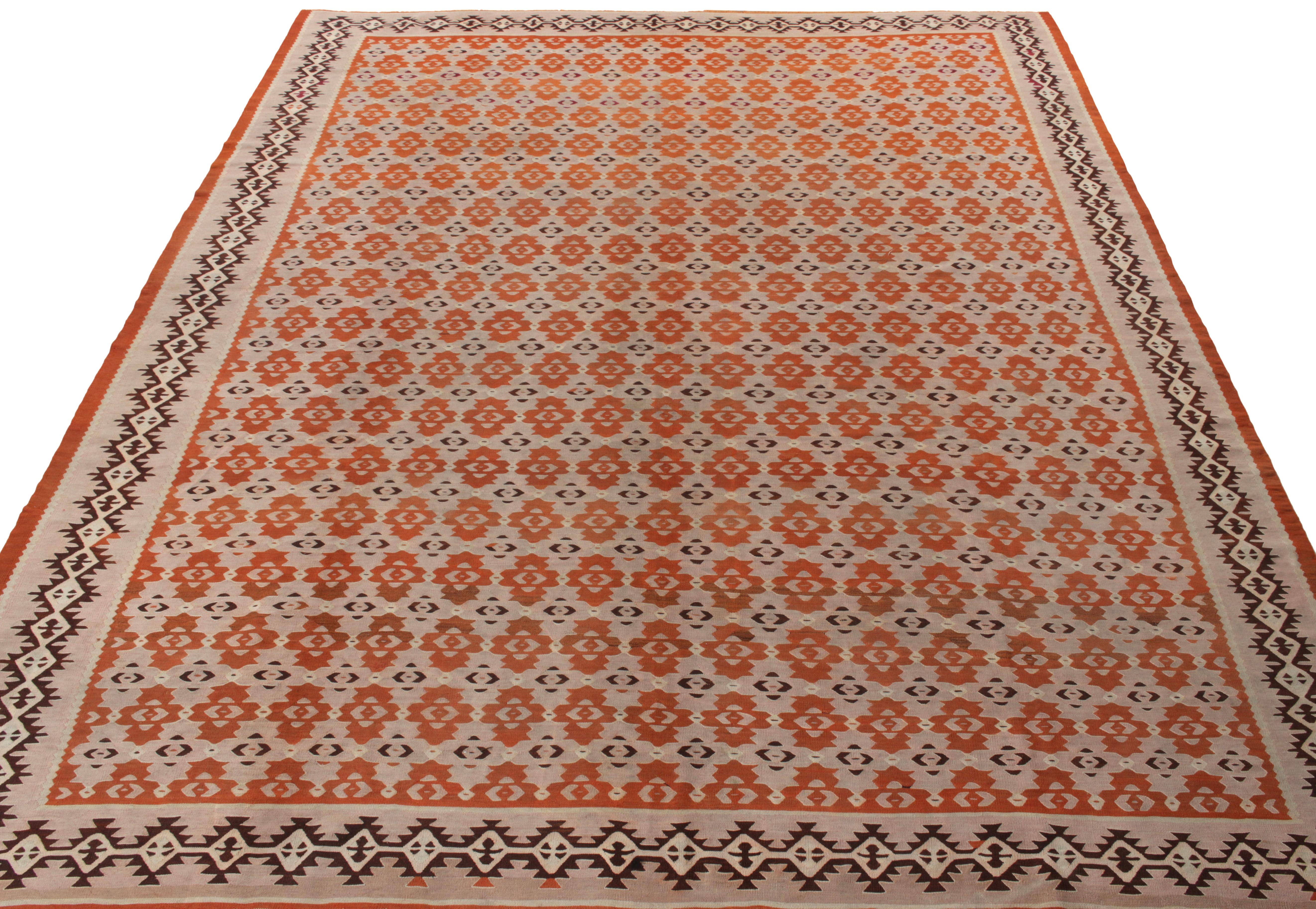 A 9x11 handwoven wool vintage kilim rug from Turkey circa 1950-1960, amongst Rug & Kilim’s fine selections of flatweaves. The luscious creamy pink scale grounds the meticulous tangerine orange geometric pattern for a scintillating sense of