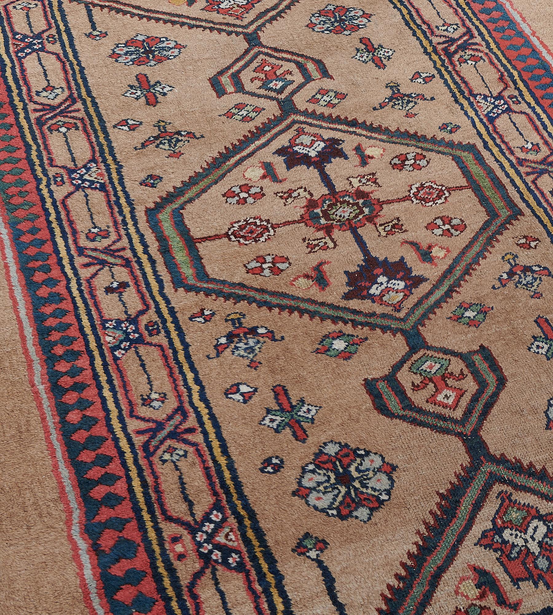 This antique, circa 1900, Serab runner has a camel-brown field with a central column of linked open serrated edged lozenges each containing a central rosette issuing angular floral motifs surrounded by polychrome floral motifs, in a camel-brown