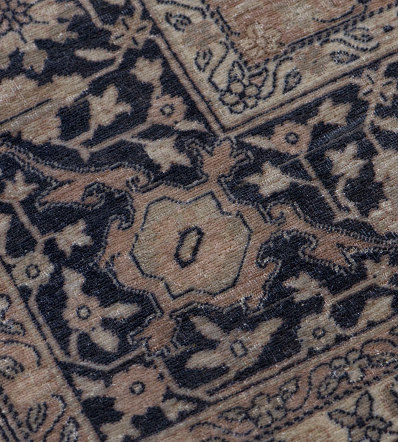 This antique Turkish Sivas carpet has a shaded buff-brown field with an overall design of charcoal-blue and ivory delicate palmette and floral vine, in a charcoal-blue border with ivory and buff-brown meandering palmette serrated leaf vine between