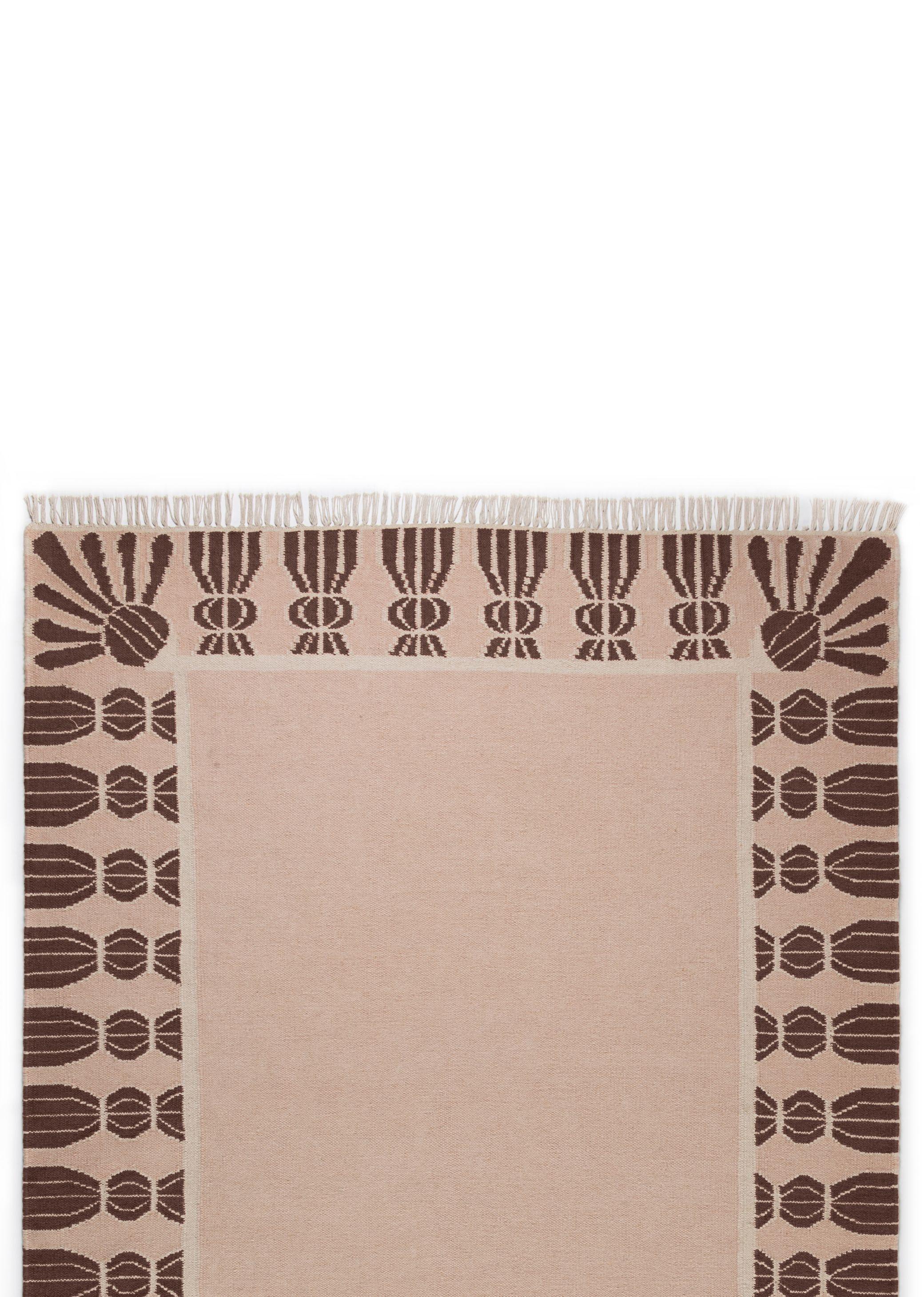 Tipicamente presenti su mobili e tendaggi, le nappe sono un dettaglio elegante che aggiunge profondità e charme a una stanza. Attingendo alla tradizione del trompe l'oeil, abbiamo reimmaginato le nappe come bordo di un tappeto per definire e