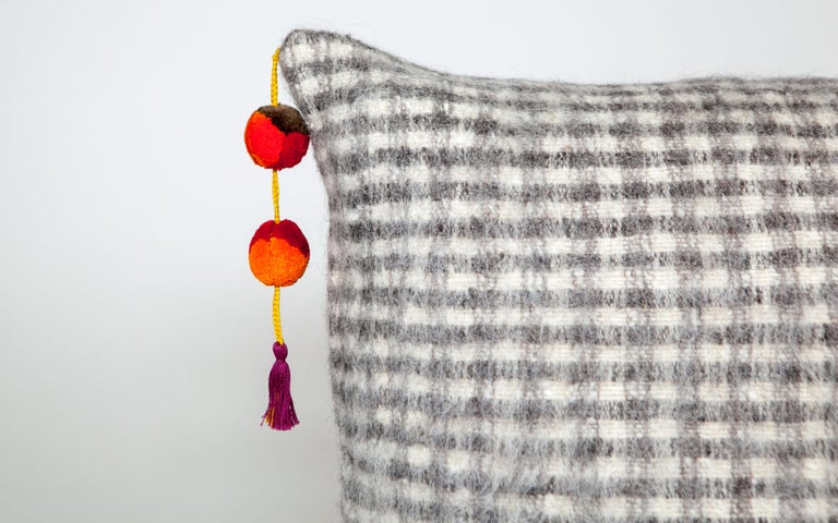 Handwoven on backstrap looms in Chamula, Chiapas, the textile of this beautiful pillow in created in checkered style with delightful cotton pom poms and made 100% from wool sheared from Chamula Community sheep, considered sacred in local