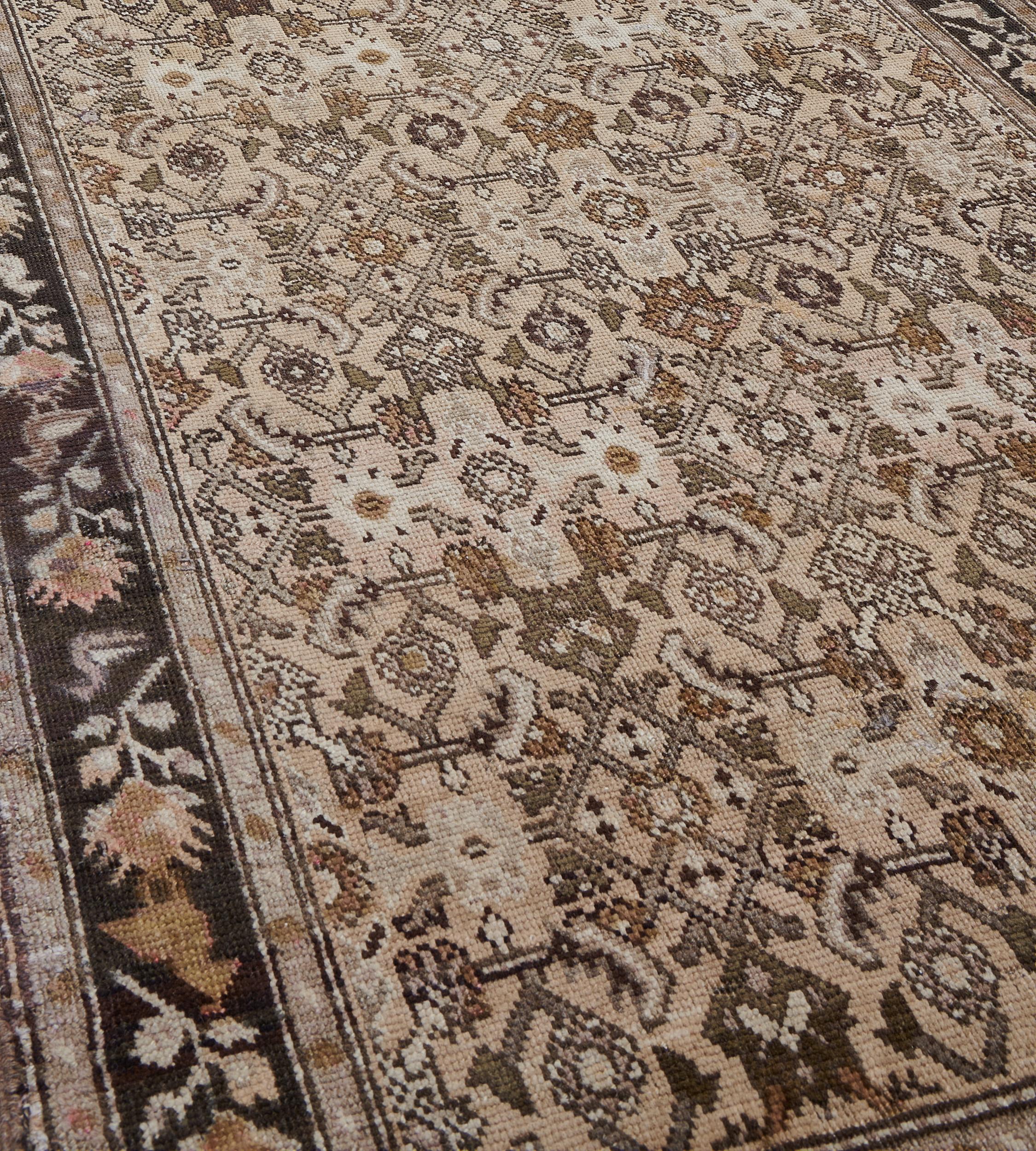 This traditional hand-woven Persian Karabagh rug has a sandy yellow field with overall tonal brown herati field, in a deep chocolate floral spray border enclosed by narrow vine stripes, plain outer tobacco line stripe.