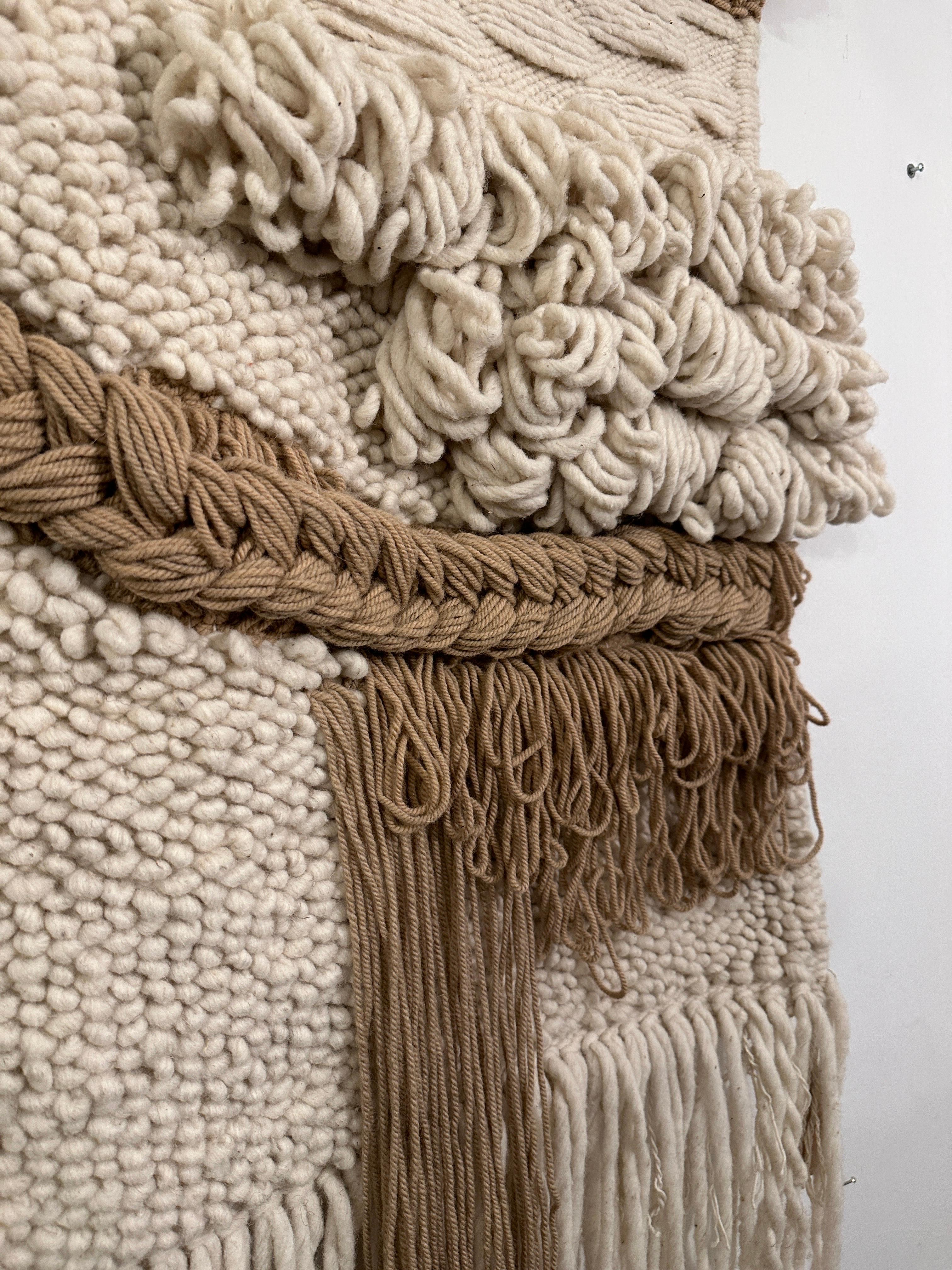 Cette magnifique tapisserie de laine bicolore tissée à la main est suspendue à une tringle en laiton conçue sur mesure et facile à fixer au mur.  CET ARTICLE EST SITUÉ ET SERA EXPÉDIÉ DEPUIS NOTRE SHOWROOM DE EAST HAMPTONS, NY.