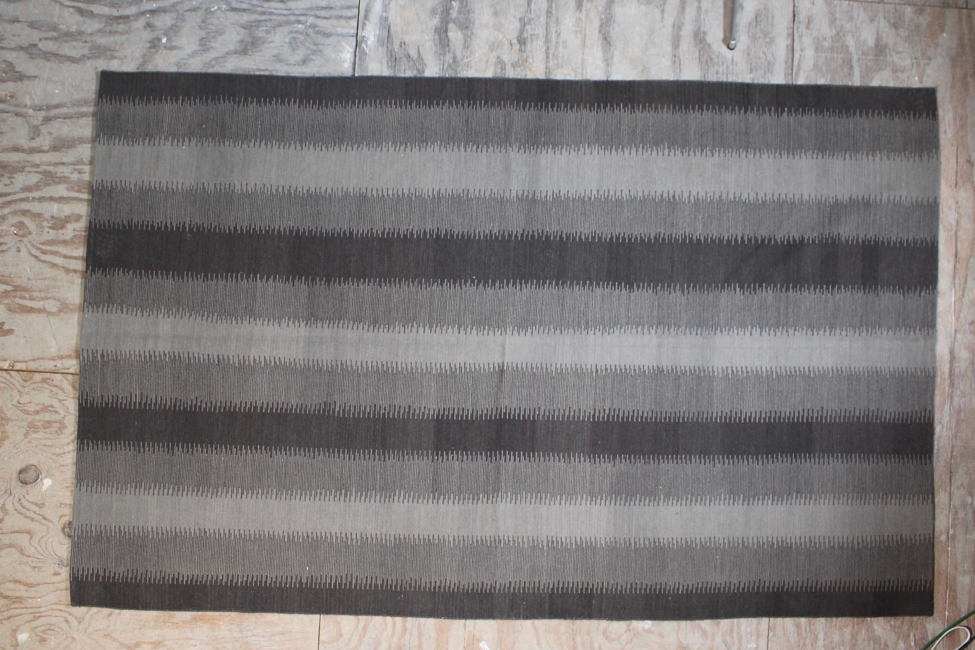 Crafted from 100% wool, this finely handwoven kilim rug offers a modern interpretation of classic early Shahsavan designs, infused with a refined mid-century aesthetic. Its elegant two-tone palette—grey and charcoal—creates a sophisticated, earthy