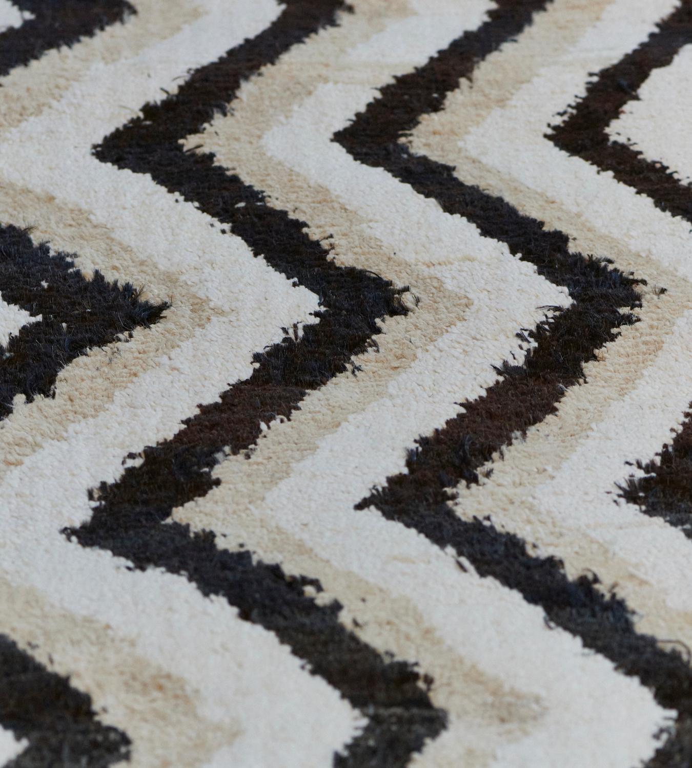 This hand-woven, medium-pile Turkish Deco rug has vertical zig-zag stripes of beige, ivory, and charcoal. Part of the Mansour Modern collection, this design is handwoven by master weavers using the finest quality techniques and materials.