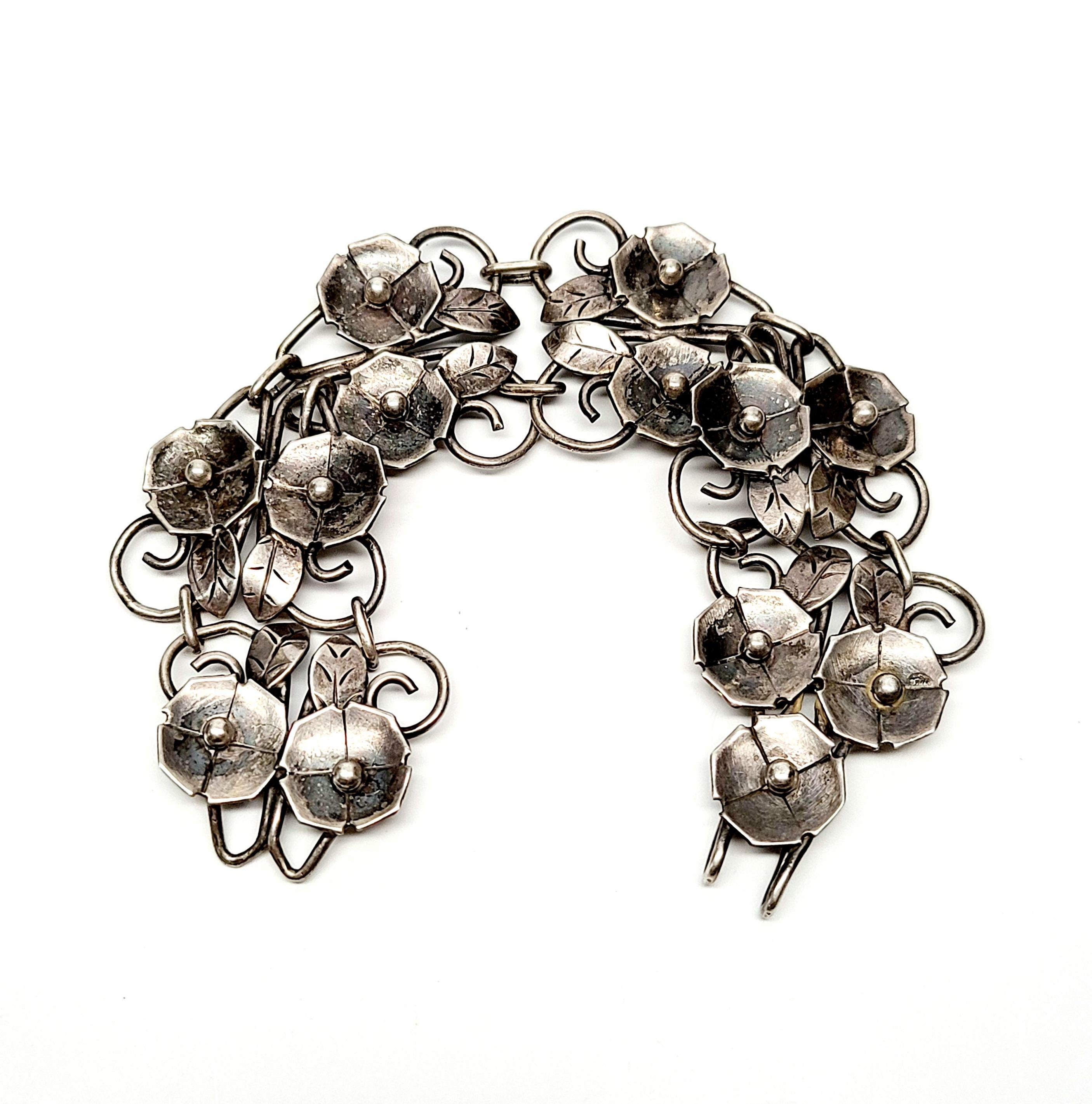 Handwrought sterling silver wide flower bracelet.

Beautiful double flower links, flowers and leaves are simple, yet detailed.

Measures approx 7