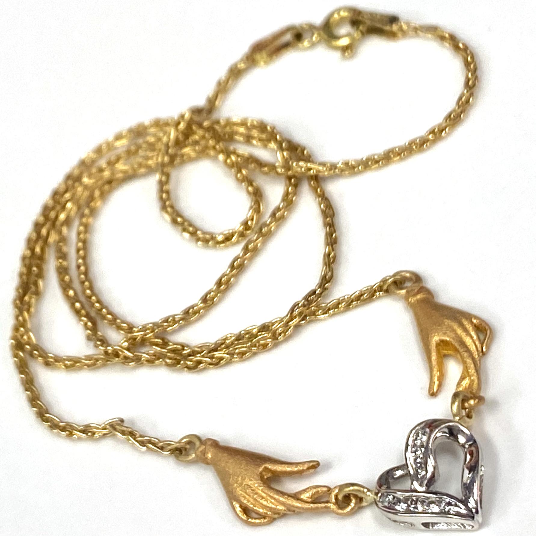 This is a fun little necklace Eytan Brandes assembled from various bits and pieces. 

The 18 karat yellow gold hands, with their cuffed gloves and frosty finish, are two of about a dozen hand charms acquired in a kooky mixed lot Eytan acquired