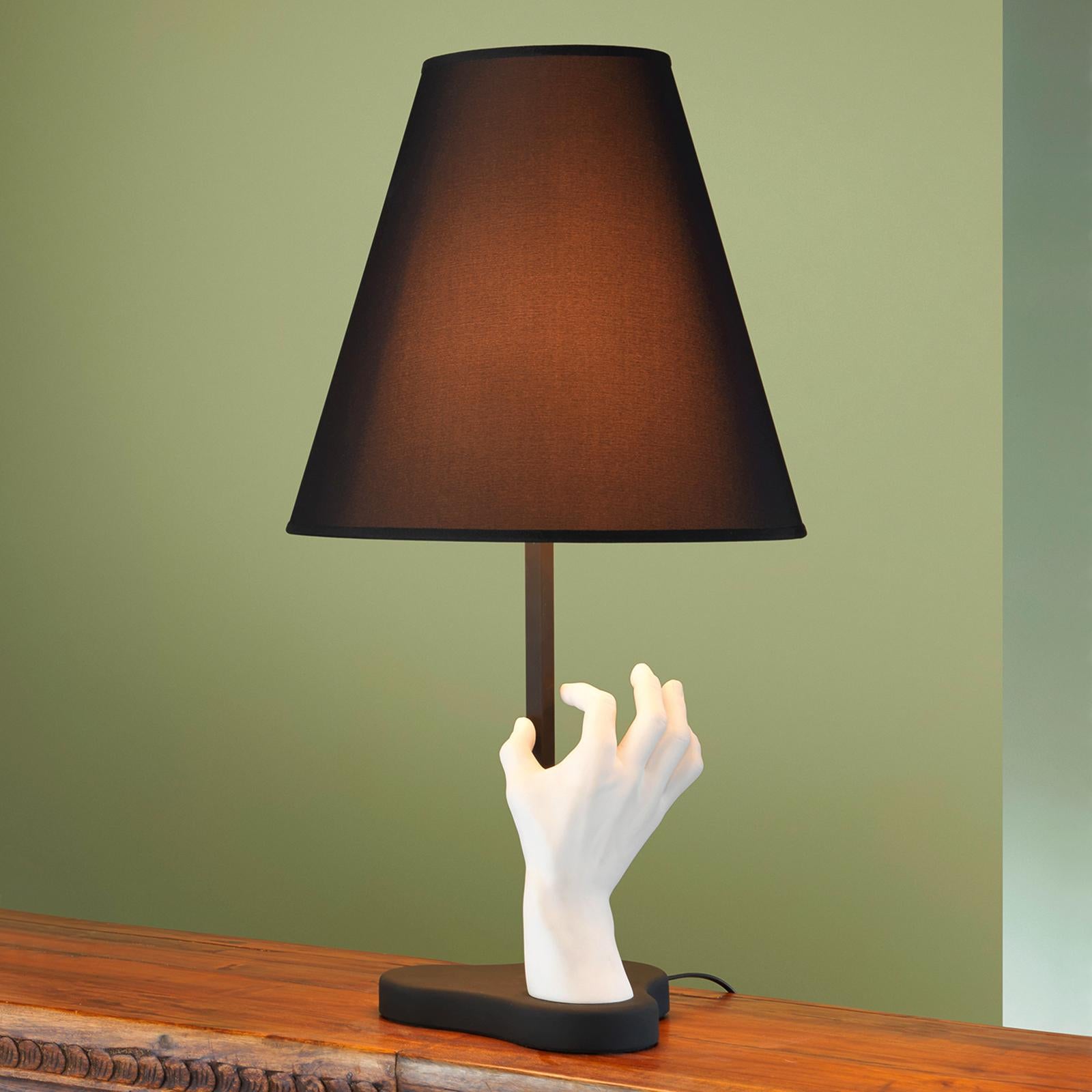 Table lamp handy with casted white hand sculpture
in powdered marble and resin and blackened base in
metal in matte finish. With shade in black fabric lined
with white PVC. With 1 bulb, lamp holder type E27, max
70 watt, bulb not included.