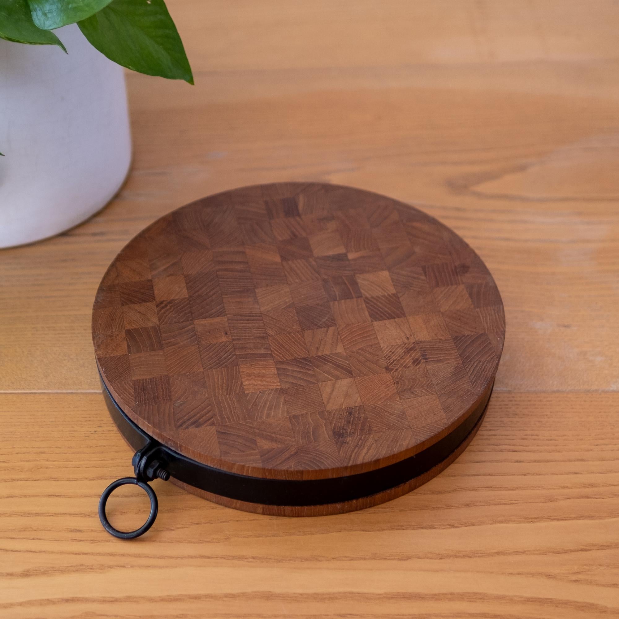 Teak hanging cutting board. Metal hoop and band around a thick dual sided teak butcher block board. Denmark, 1960s.