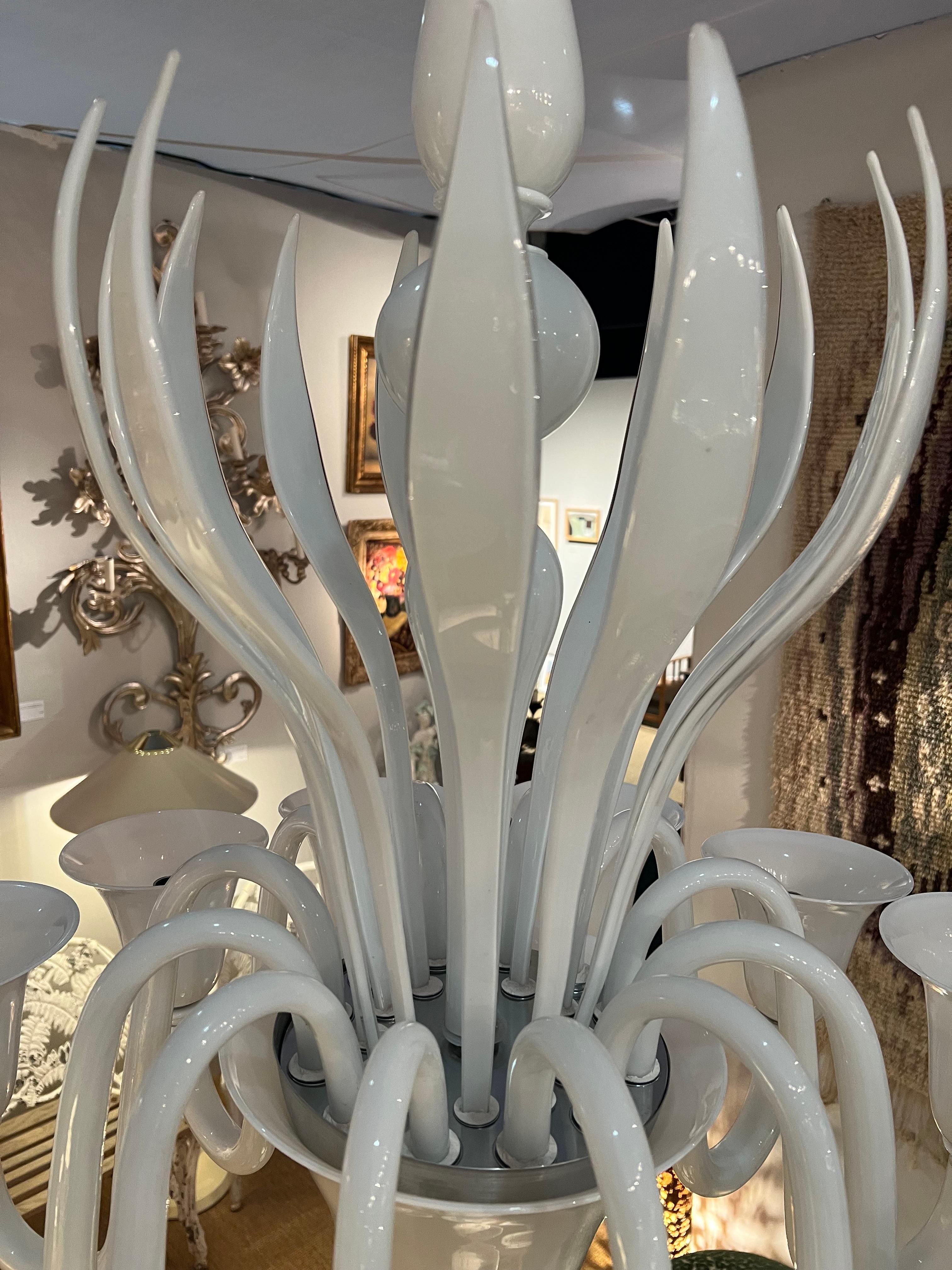 Questo squisito lampadario di Murano, realizzato negli anni '70, incarna l'eleganza senza tempo e l'eccezionale maestria della lavorazione del vetro di Venezia. Interamente in bianco, il suo design elegante e minimalista offre una presenza