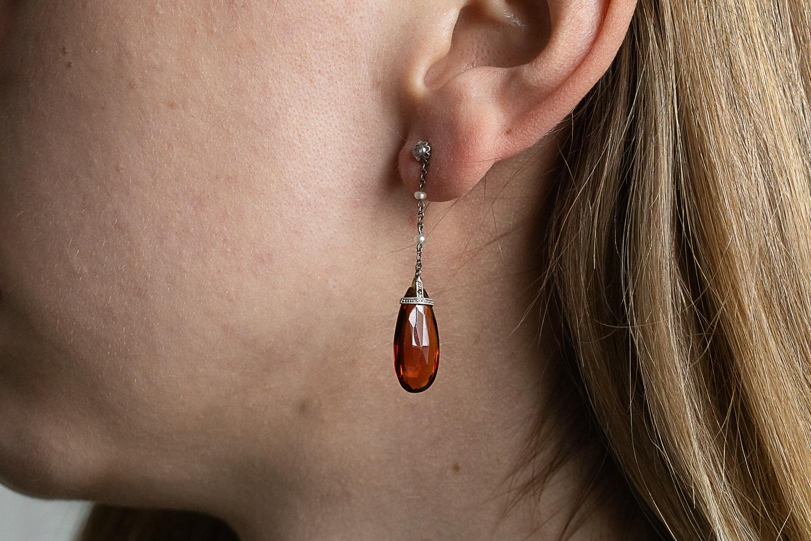 Earrings with two faceted citrines, diamonds and pearls.

Hanging earrings with citrines, diamonds and pearls. Earrings made of 14-karat yellow gold (0.585 fineness) and silver. Old earrings with four rose-cut diamonds with a total weight of approx.