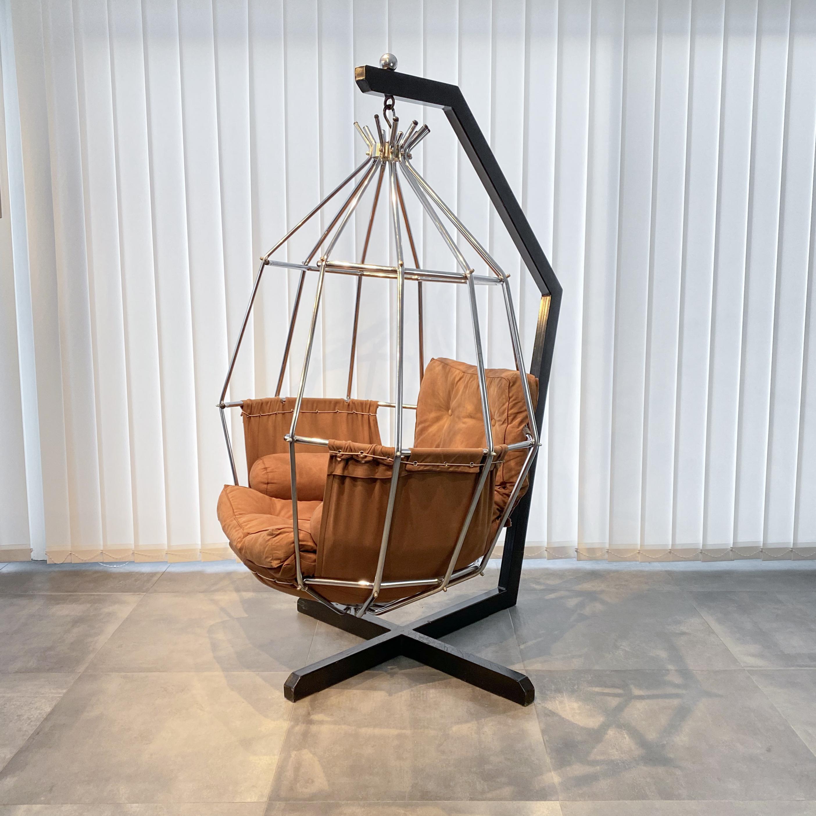 Hängesessel Gojan, entworfen von dem dänischen Architekten Ib Arberg für den schwedischen Hersteller ABRA Möbler. Dieser bemerkenswerte Stuhl besteht aus einem verchromten Metallkäfig, der an einem schwarzen Stahlgestell aufgehängt ist. Die