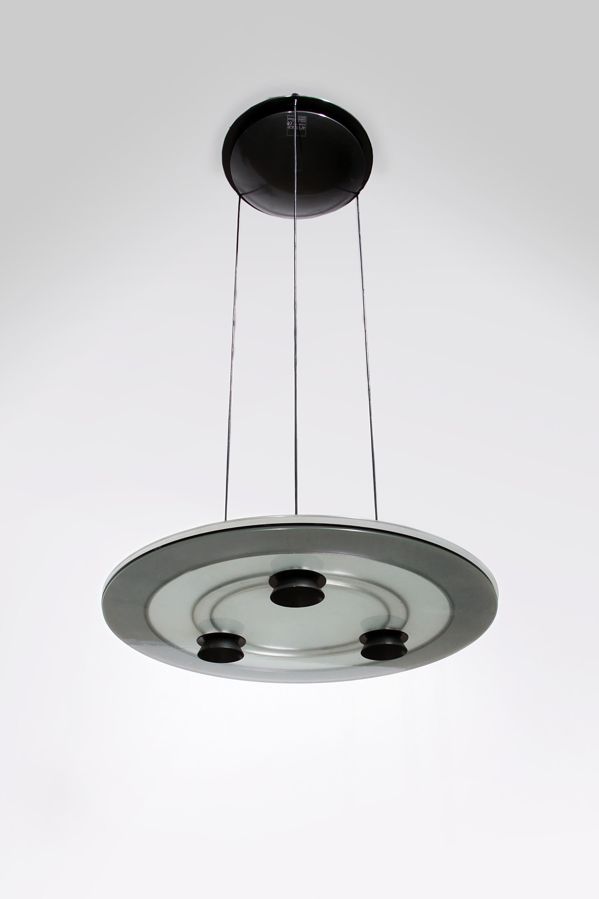The Arteluce Aurora Hanging Lamp, designed by Perry King and Santiago Miranda in 1983, is a timeless addition to any interior. This unique lamp offers both direct and diffuse light thanks to the three 50 W halogen spotlights. The Aurora is