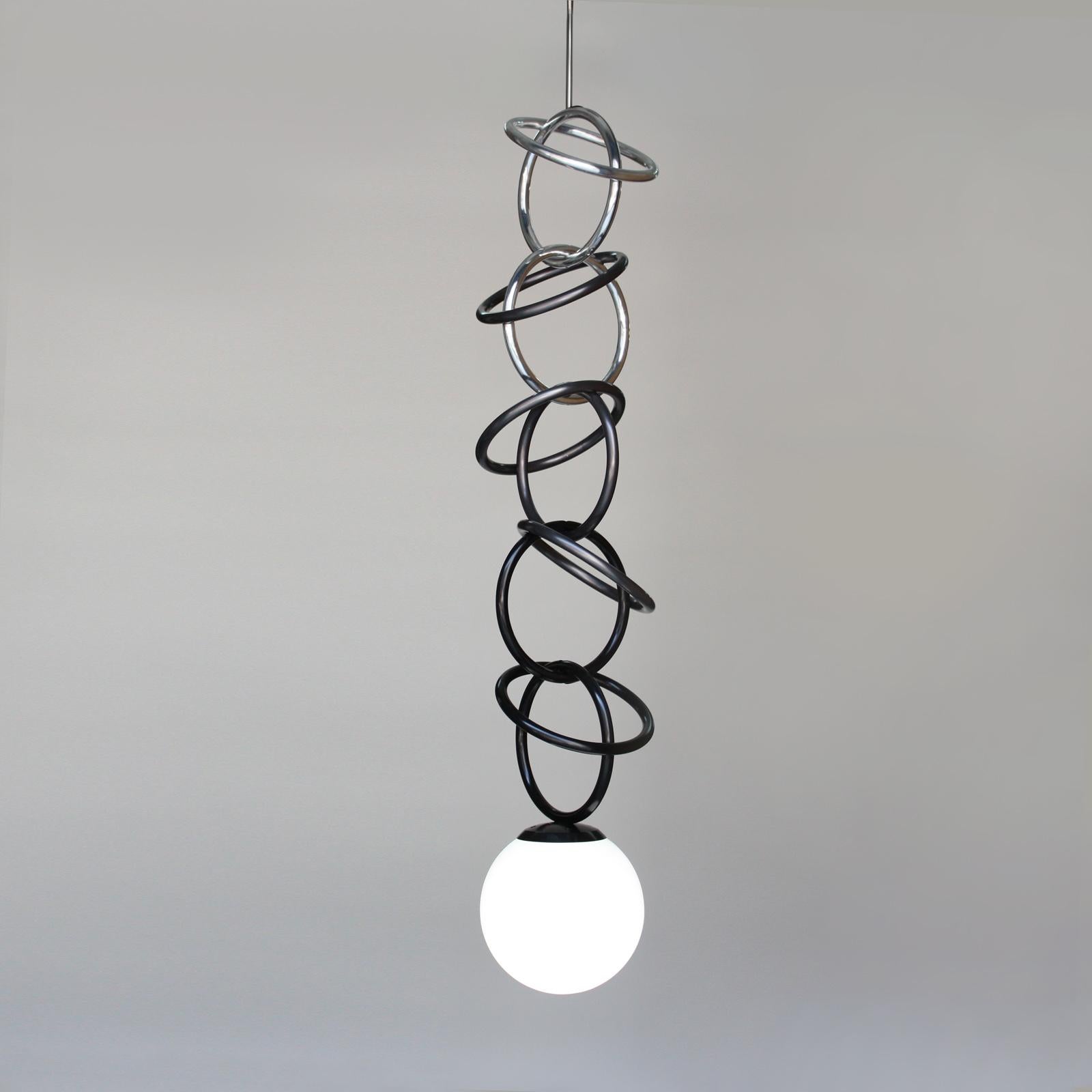 Inspired by jewelry links, this oversized ceiling lamp is a dramatic accent and decoration for your home. It's a mixture of complementary metal finishes cascading from light to dark, finished with a luminous pearl-like glass orb at the