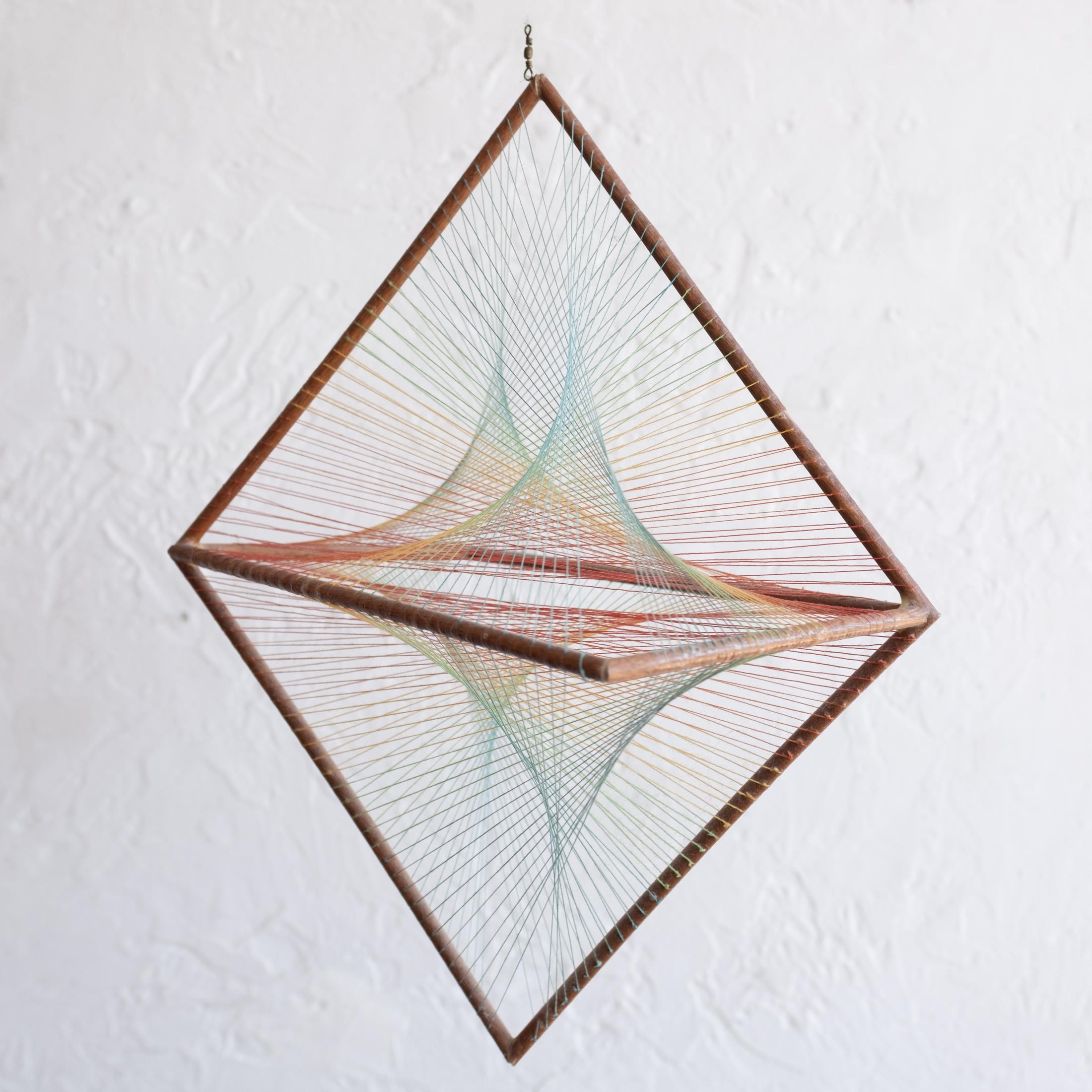 Hanging mid-century fiber and wood kinetic sculpture.  Unsigned, 1960s