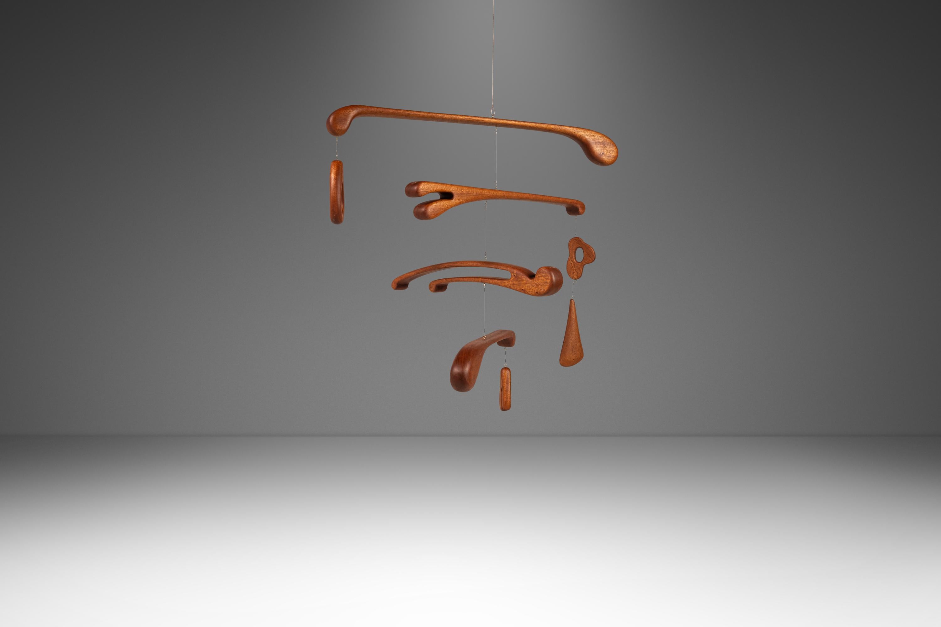  Dale a tu hogar un toque de elegancia orgánica con este móvil de guardería colgante único en su especie, diseñado y tallado por Mark LeBlanc. Elaborado con maestría a partir de caoba Sapele africana de origen raro e intencionado, este móvil presume