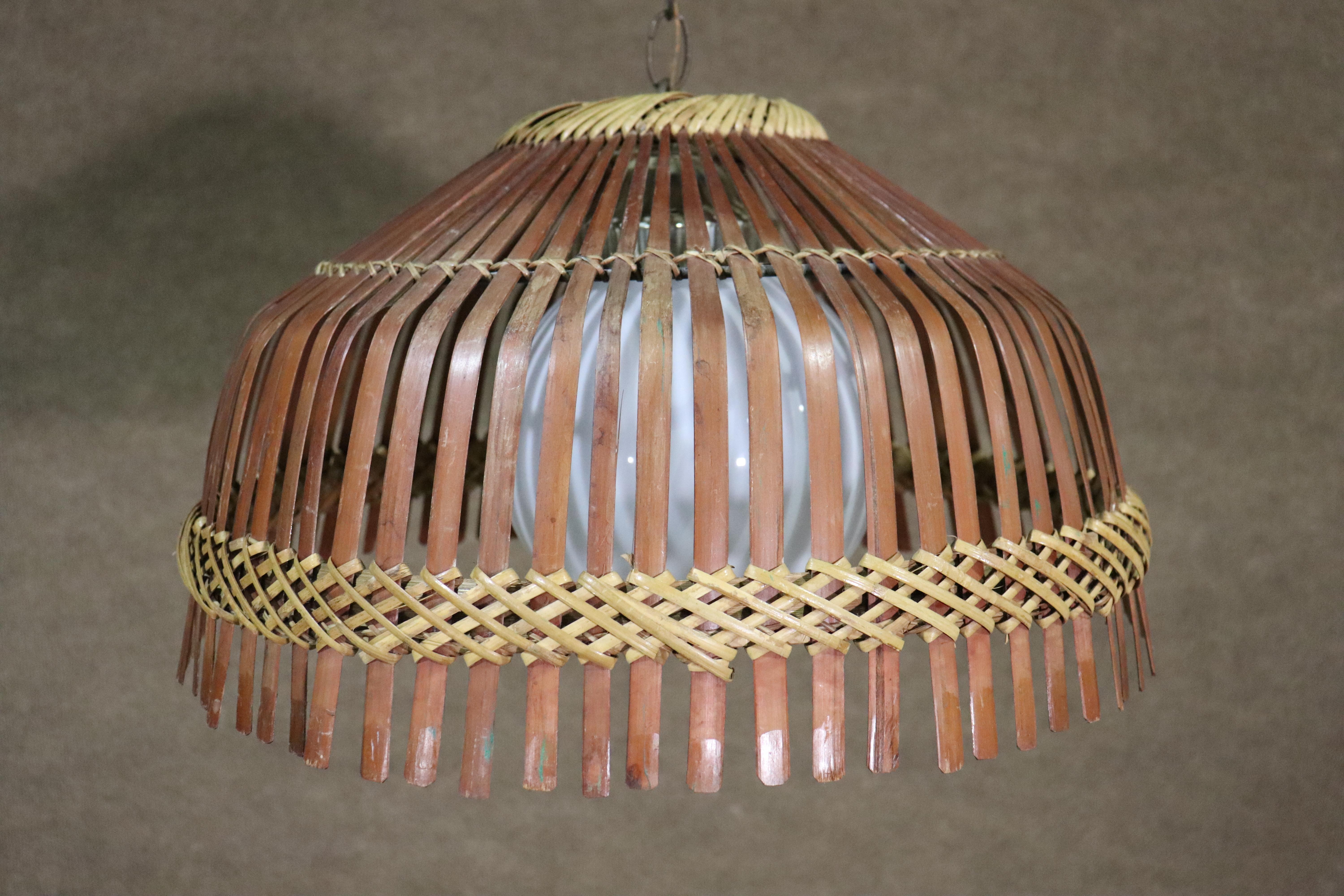 Vintage hanging lamp with wide split rattan shade, with woven wicker. Large milk glass globe holds a single bulb.
Please confirm location NY or NJ