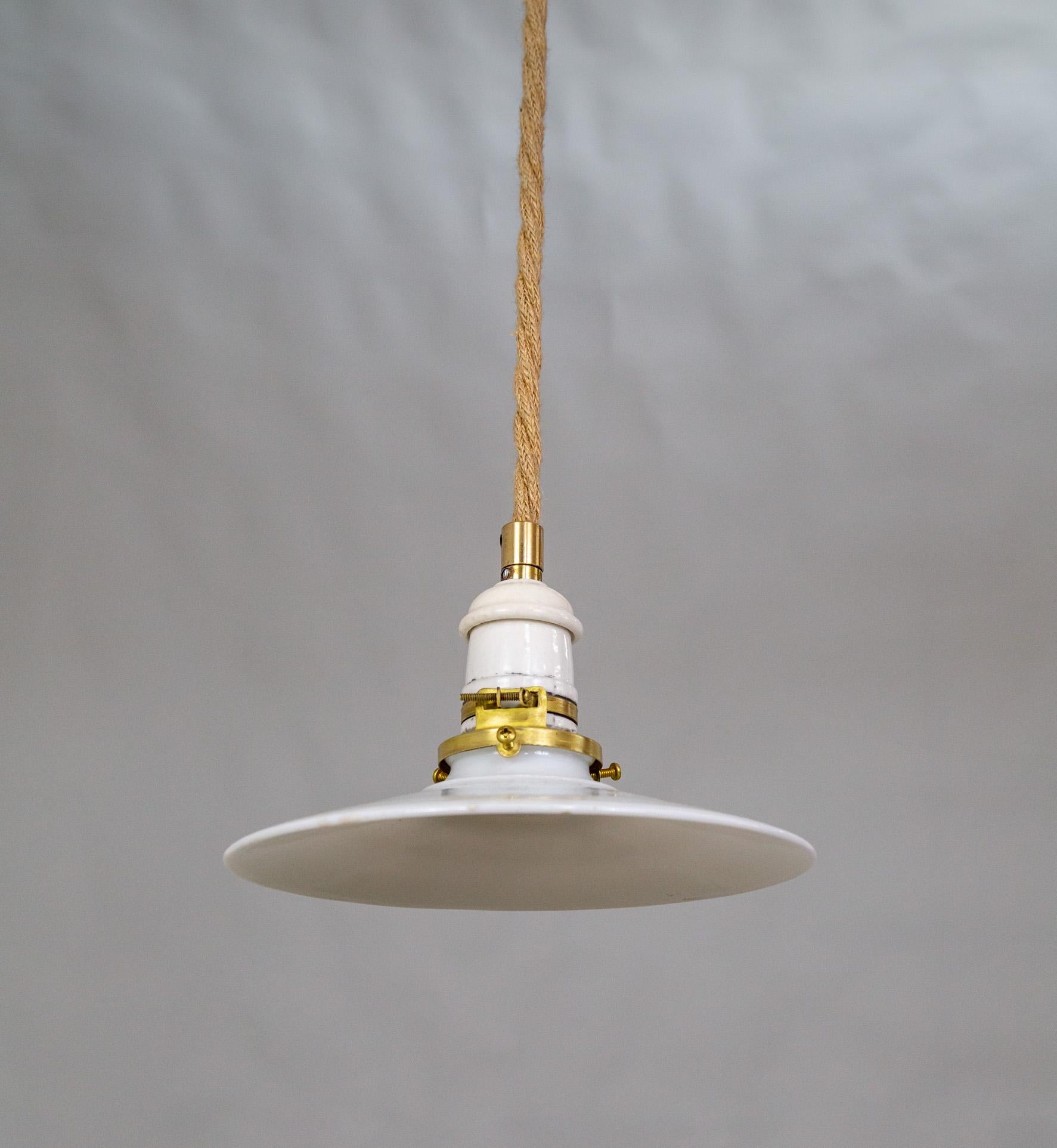 Una lampada a sospensione contemporanea con un cavo rivestito in corda, un piccolo paralume in vetro latte e un baldacchino in ceramica e ottone.  Lunghezza del Corde personalizzabile. 69