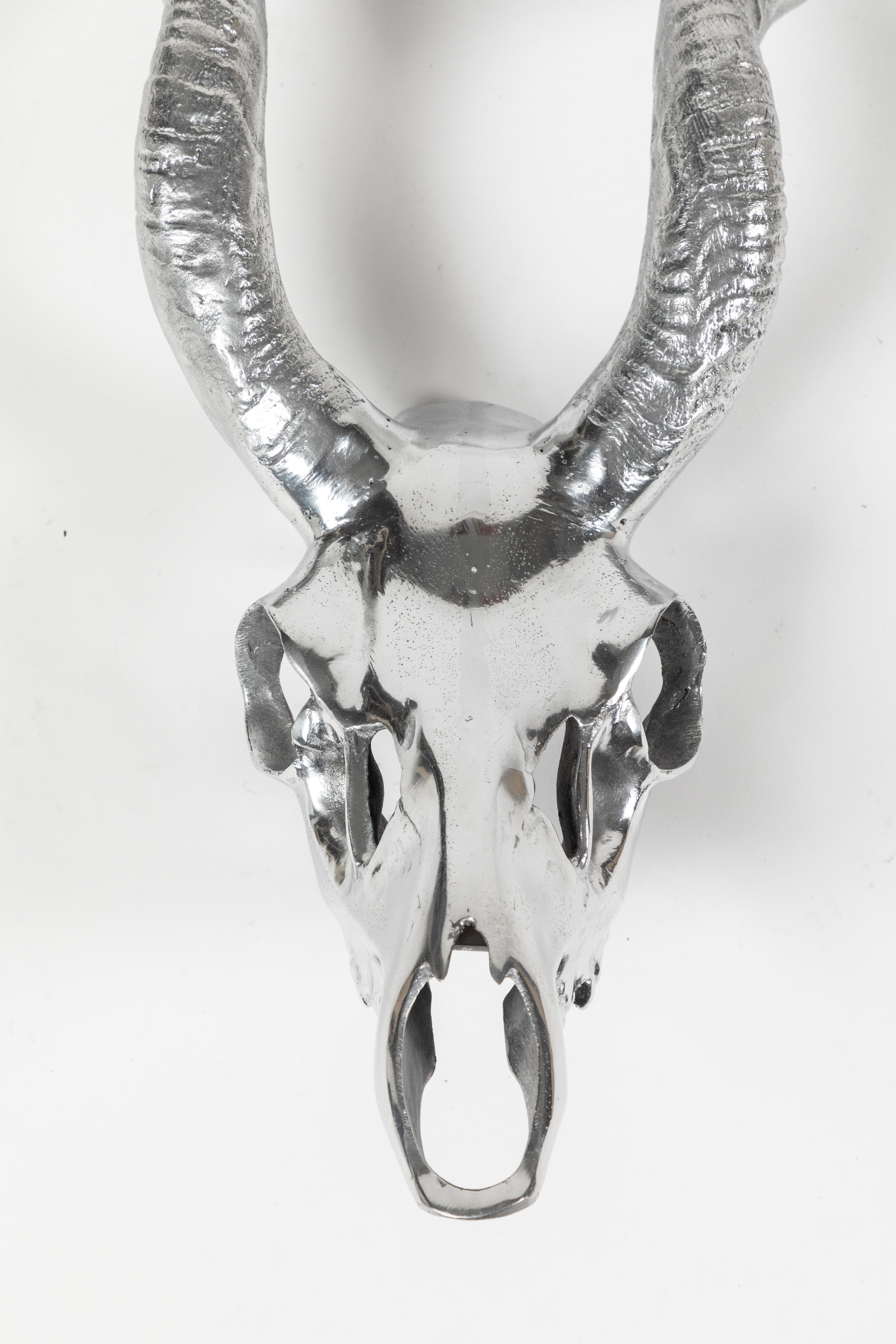 This Kudu skull sculpture by Arthur Court is casted in aluminum. It has a a bracket on the back for a wall mount. It is stamped, 