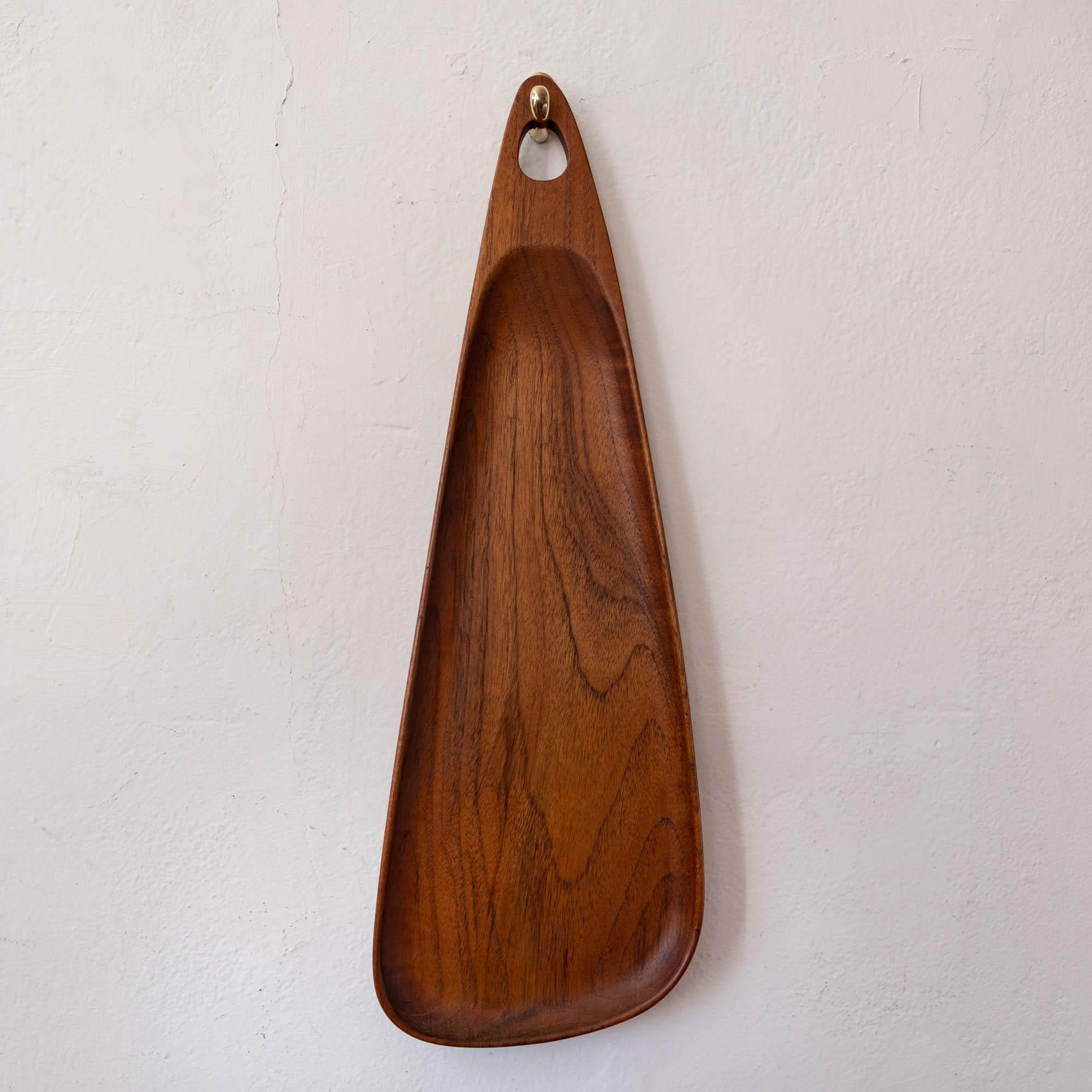 Sculpted teak wall hung tray by Digsmed, from the midcentury. Hangs on a brass hook. Denmark, 1950s.