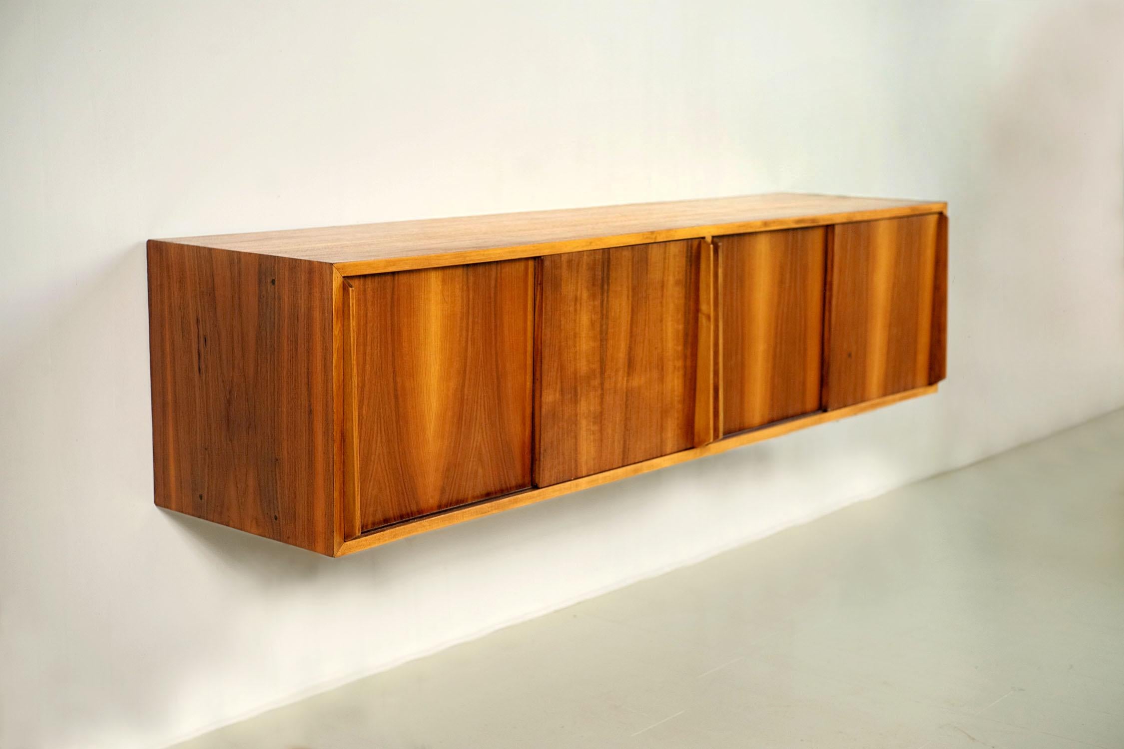 Hanging sideboard in flamed walnut, Italy 1955. Equipped with 4 sliding doors with large handles, this superb sideboard has a central shelf. It comes from the furniture of the first apartment-hotel founded in Ventimiglia in 1955. All the specific